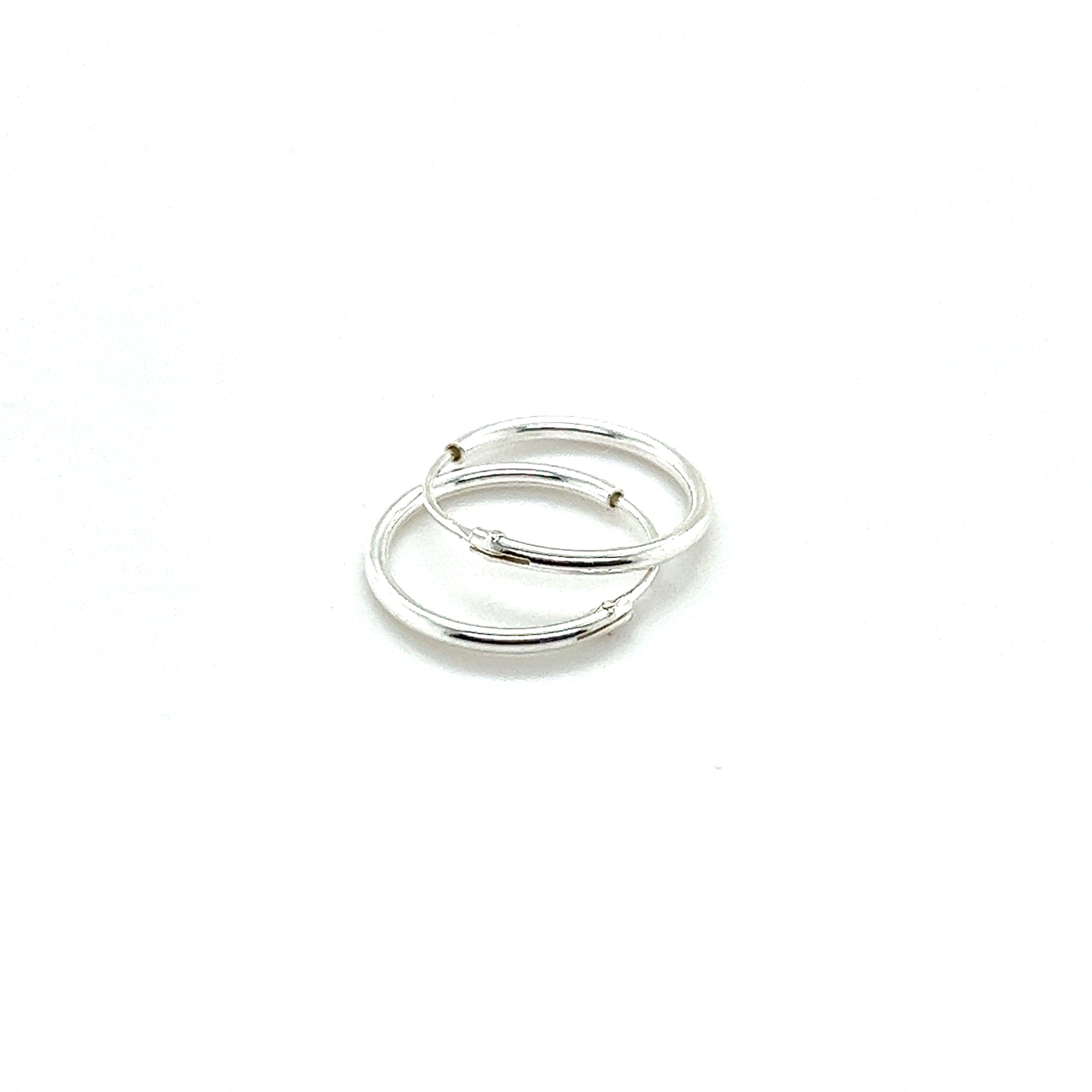 Two elegant 1.2mm Infinity Hoops crafted from .925 sterling silver showcase a timeless design on a pristine white background.
