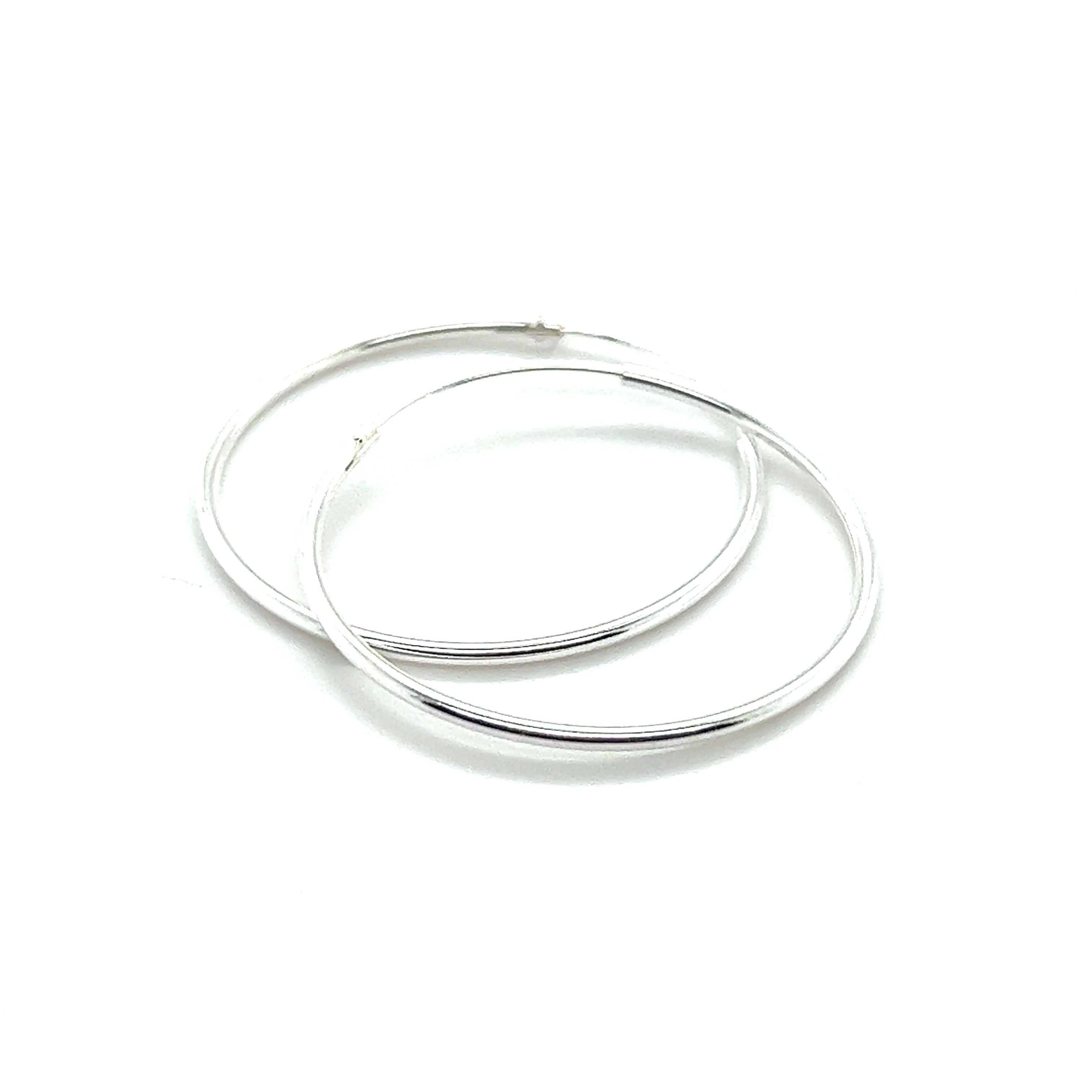 Two 1.2mm Infinity Hoops, crafted from .925 Sterling Silver with a sleek infinity hoop design, are placed on a white background.