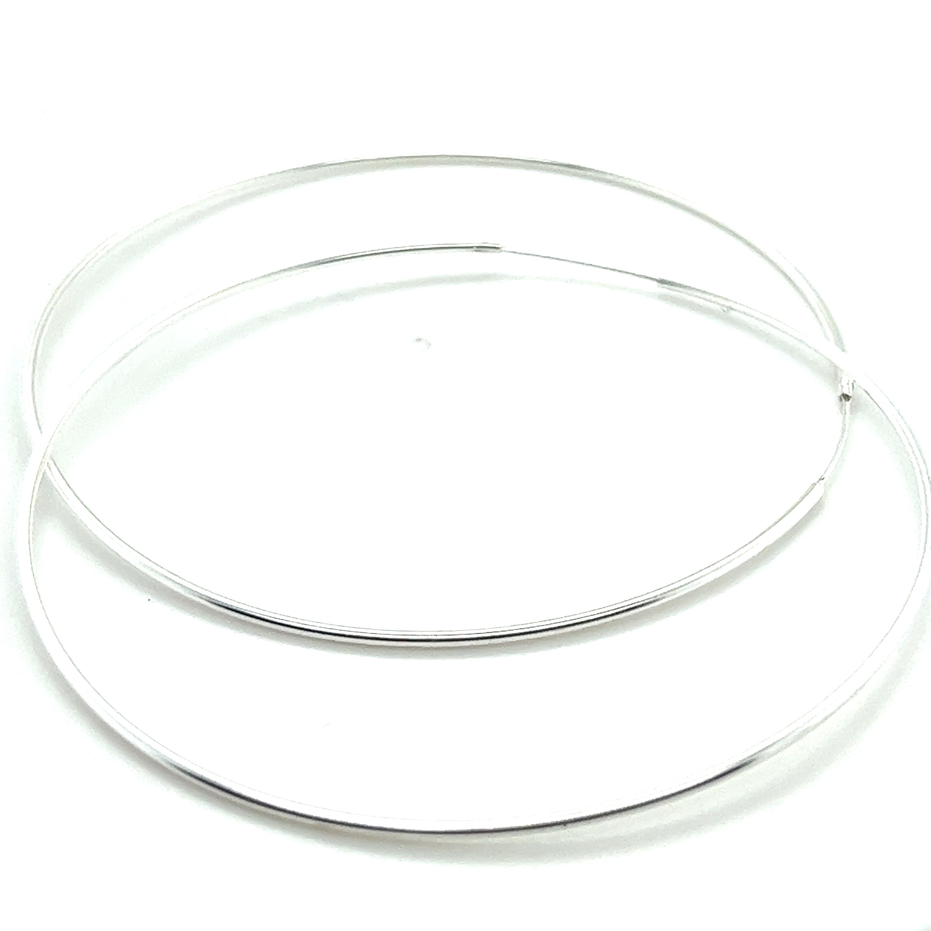A pair of delicate 1.2mm Infinity Hoops made from .925 Sterling Silver featured against a white background.