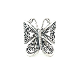 A minimalist large silver butterfly ring on a white background.