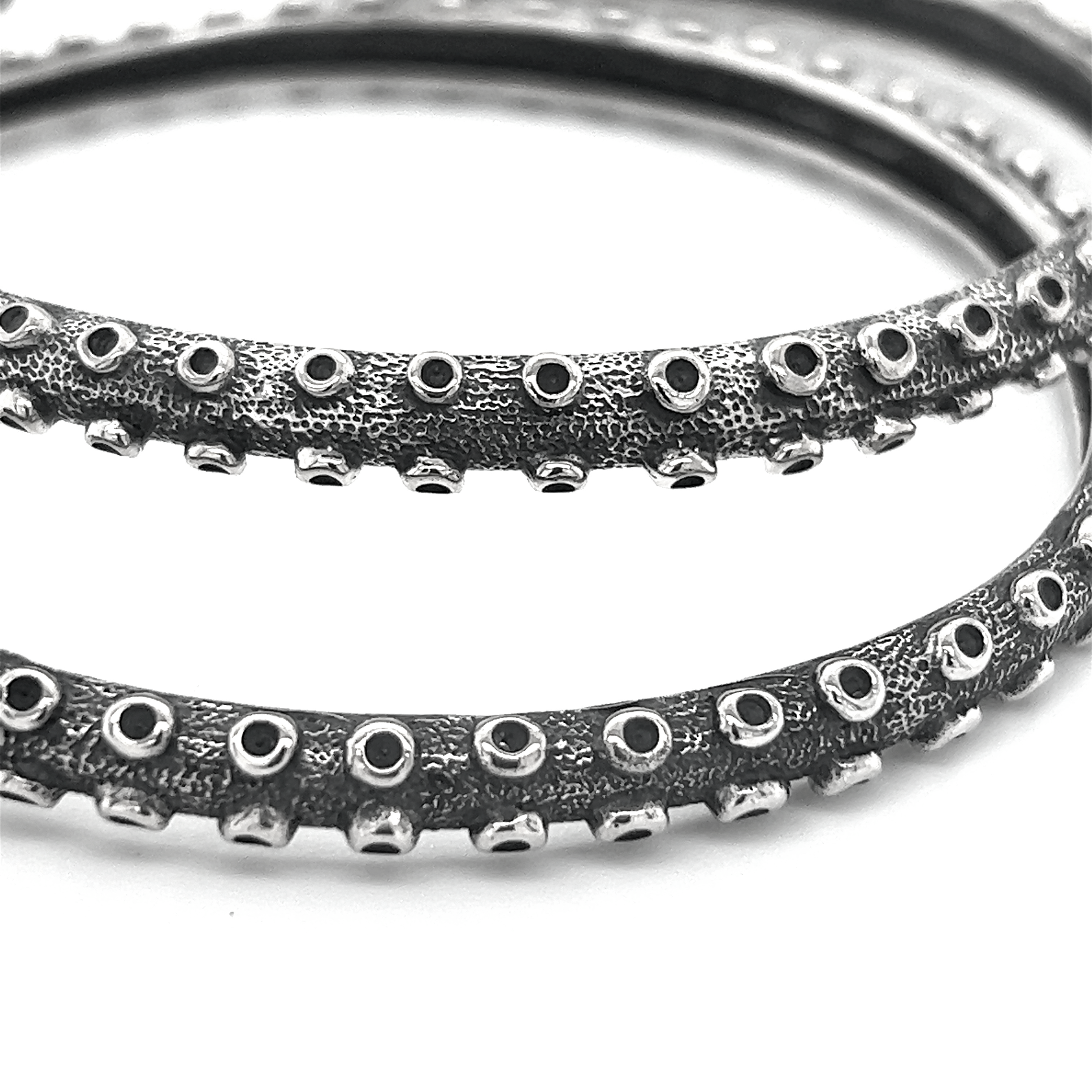 A mesmerizing pair of Super Silver Colossal Tentacle Hoops on a white surface.