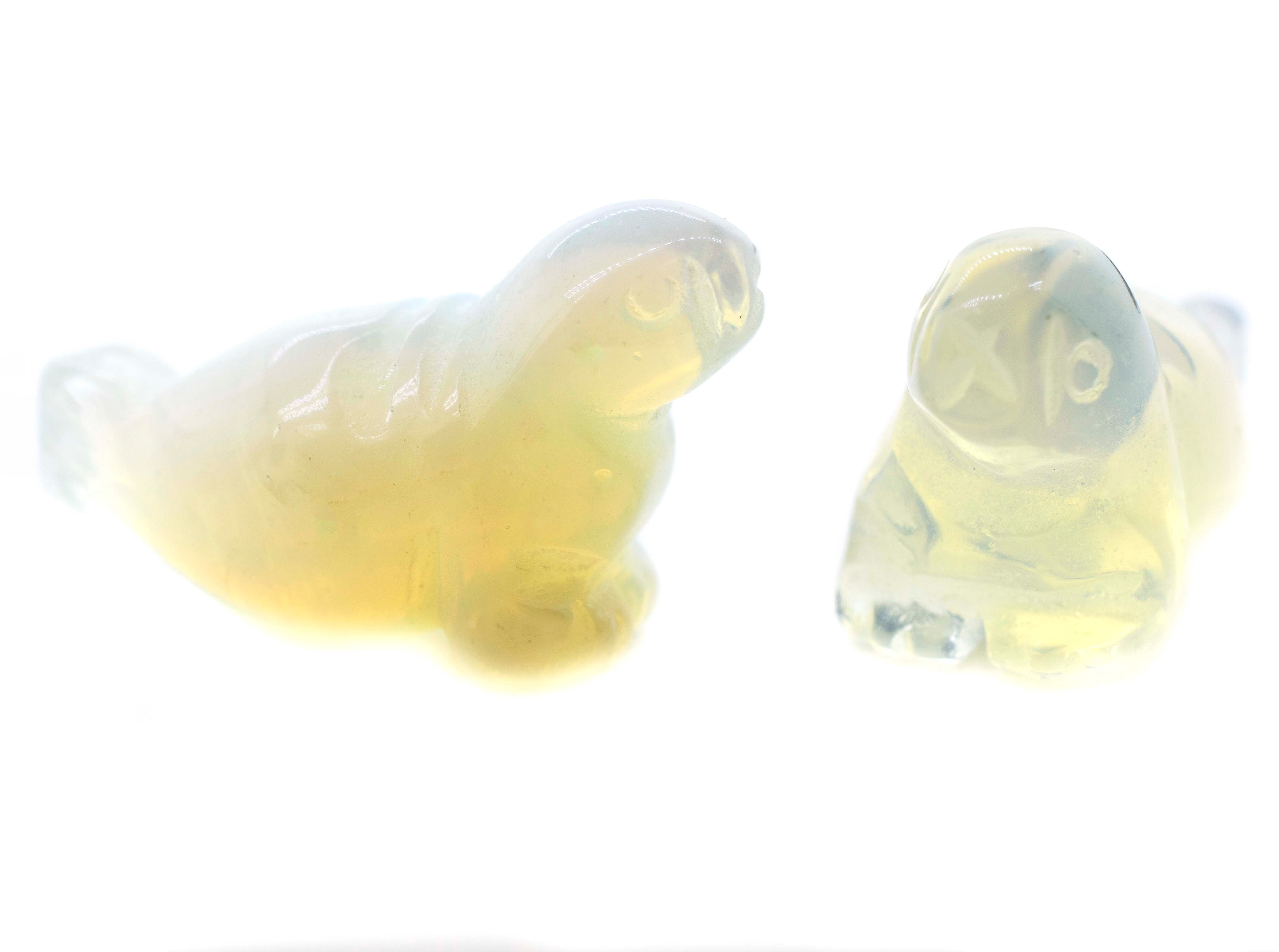 A pair of Carved Opalite Seal Figures on a white background.