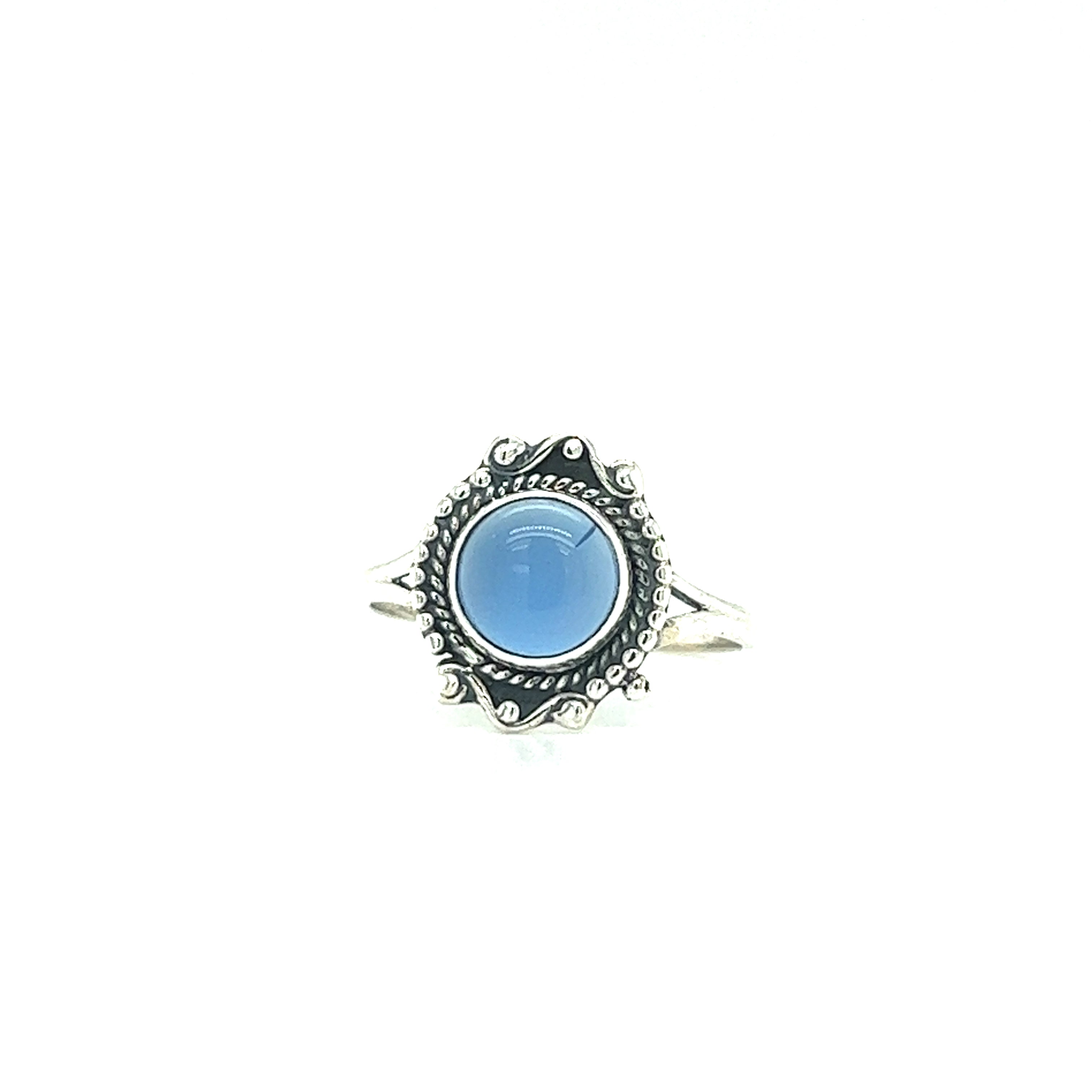 A Round Gemstone Ring With Vintage Setting with an ornate band, featuring a round blue stone in the center, set against a white background. This vintage-style gemstone ring effortlessly evokes a touch of Bohemian jewelry charm.
