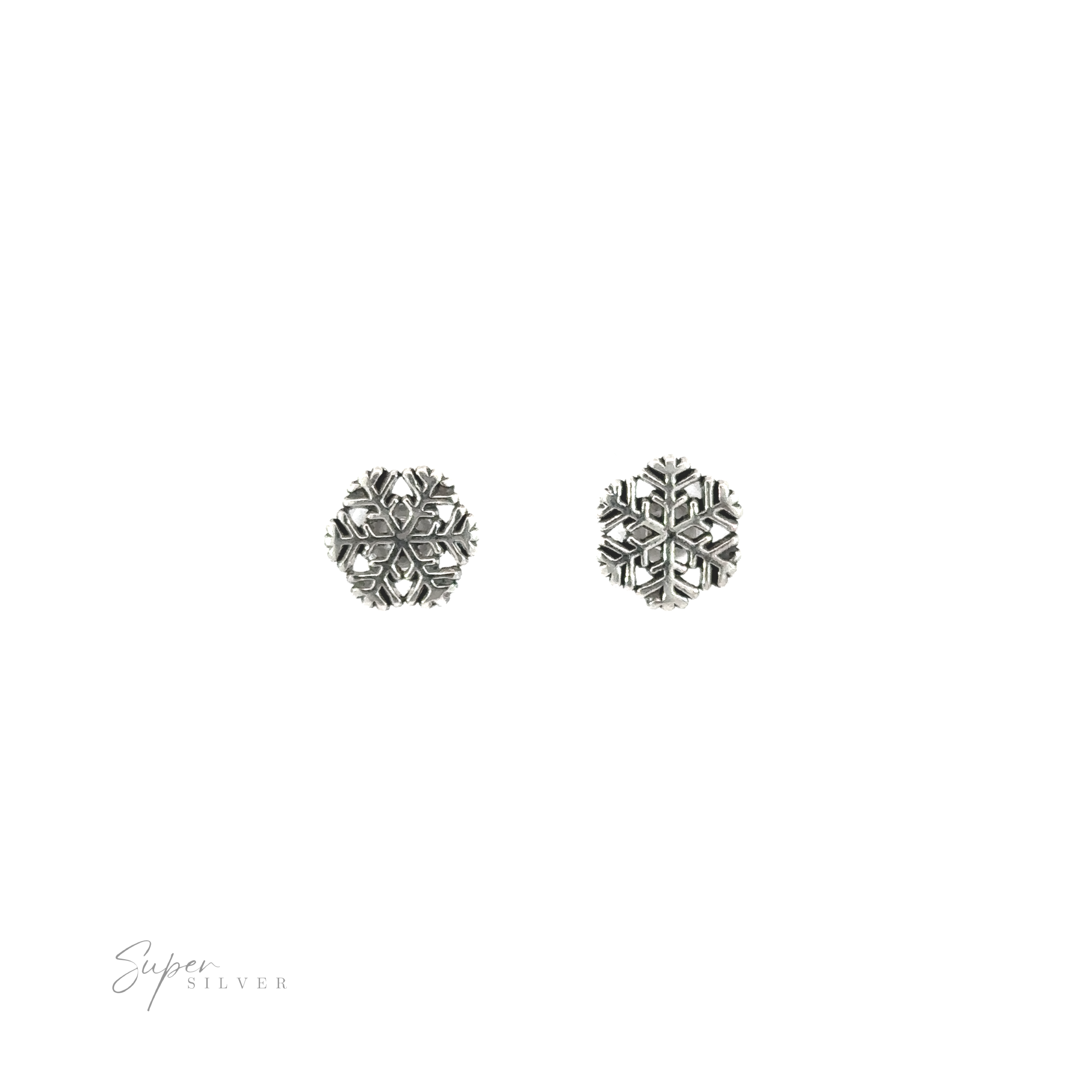 A pair of Delicate Snowflake Studs on a white background, evoking seasonal cheer.