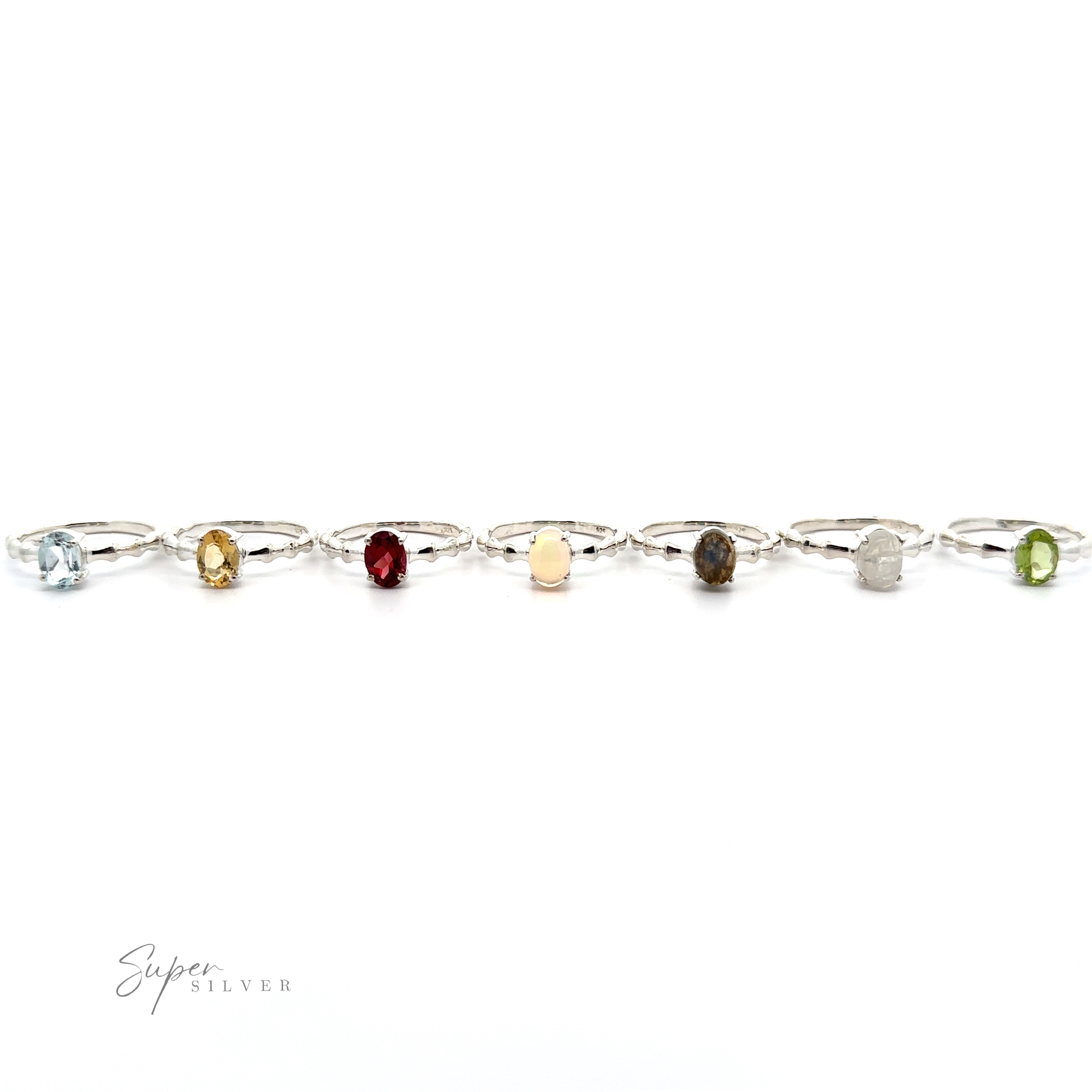A Pronged Oval Gemstone Ring with Textured Band with various colored stones linked together on a white background.