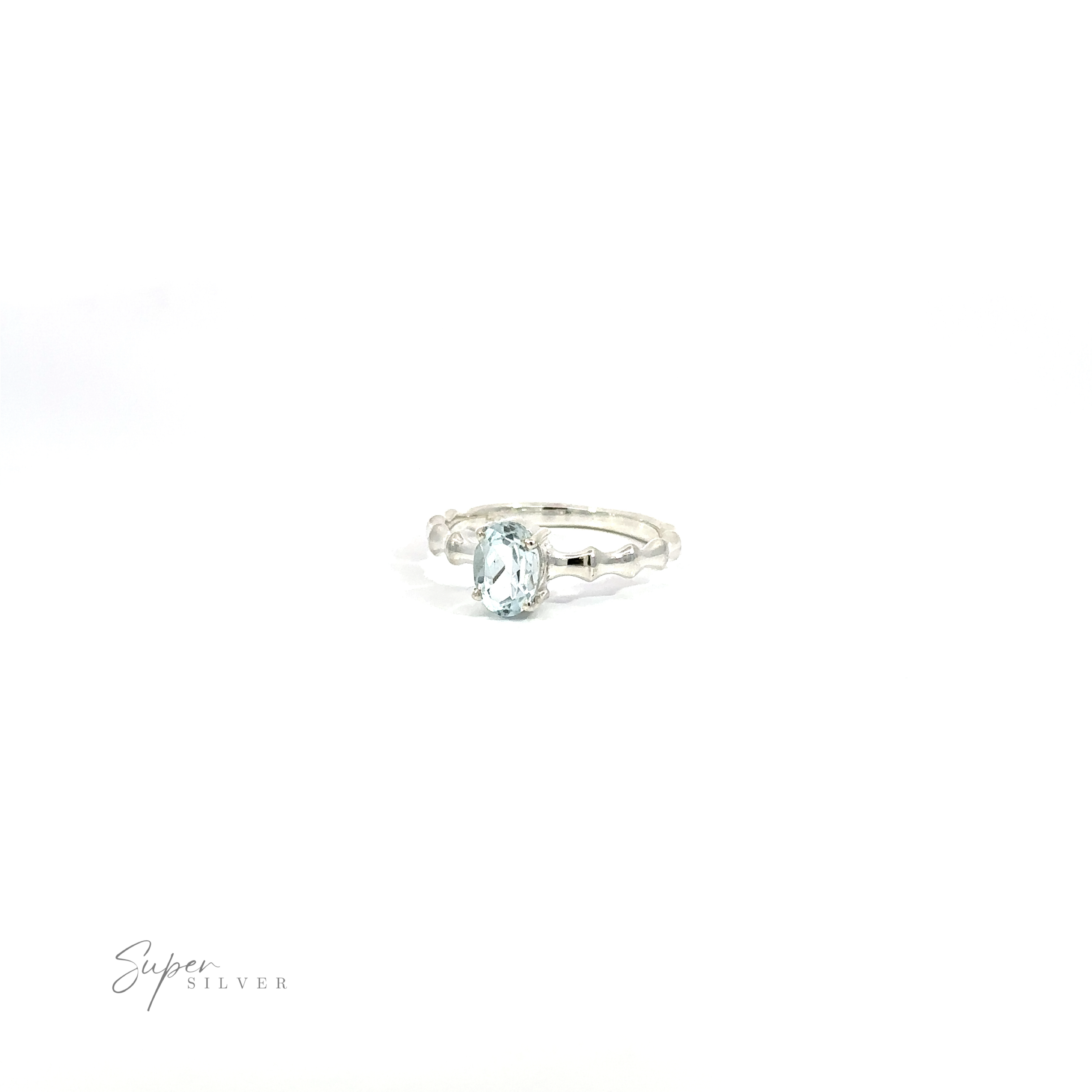 Pronged Oval Gemstone Ring with Textured Band with a single oval Blue Topaz on a white background.