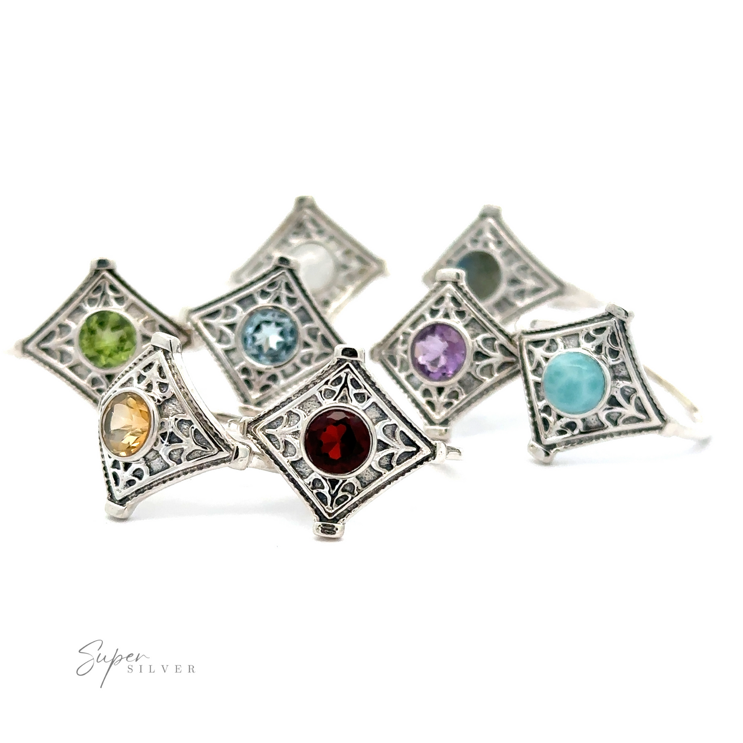 A collection of intricate diamond silver rings with round gemstones, each featuring a different colored gemstone, artistically arranged on a white background.