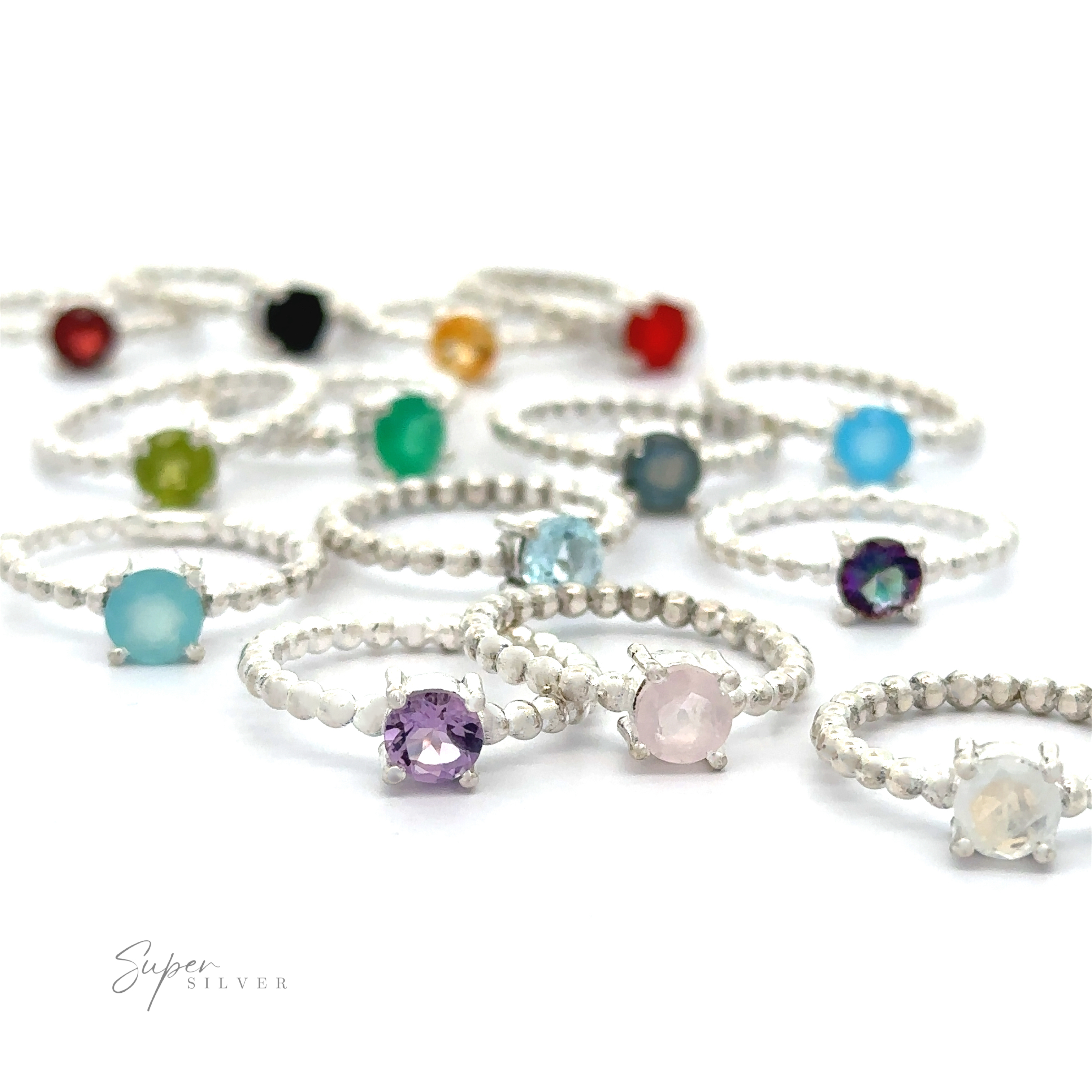 A collection of vibrant, Stunning Circular Gemstone Rings with Beaded Bands on a white surface.