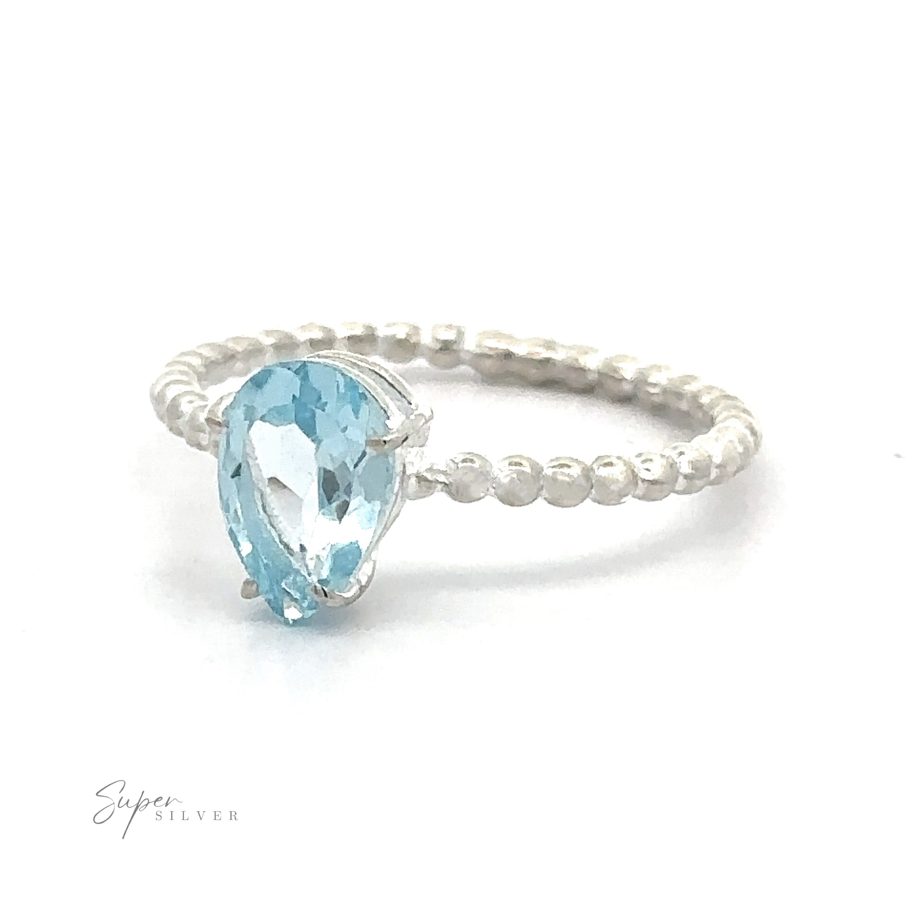 A Vibrant Teardrop Gemstone Ring with Beaded Band with a pear-shaped blue teardrop gemstone in a prong setting on a white background.