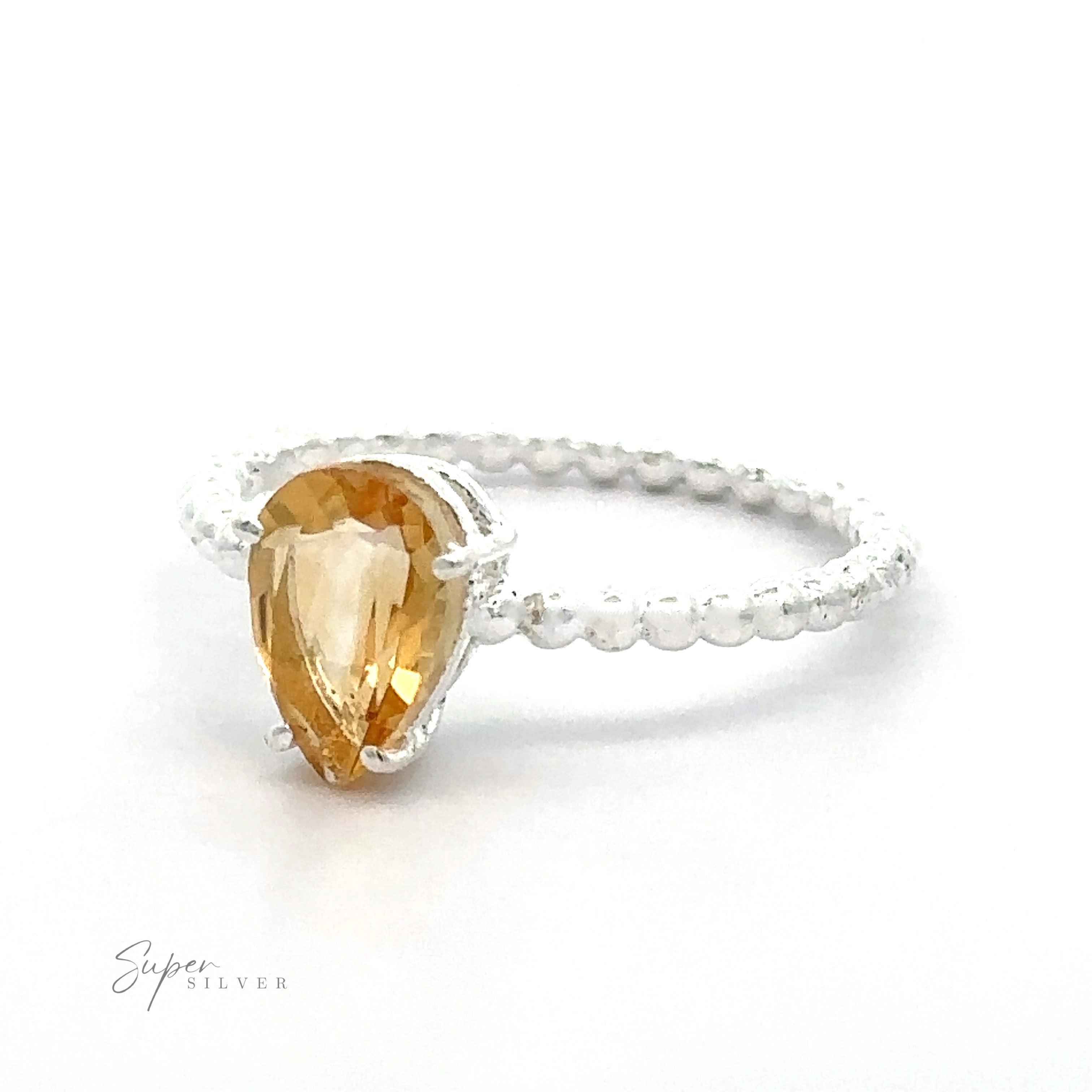 A Vibrant Teardrop Gemstone Ring with Beaded Band with a vibrant color, pear-shaped yellow gemstone on a white background.