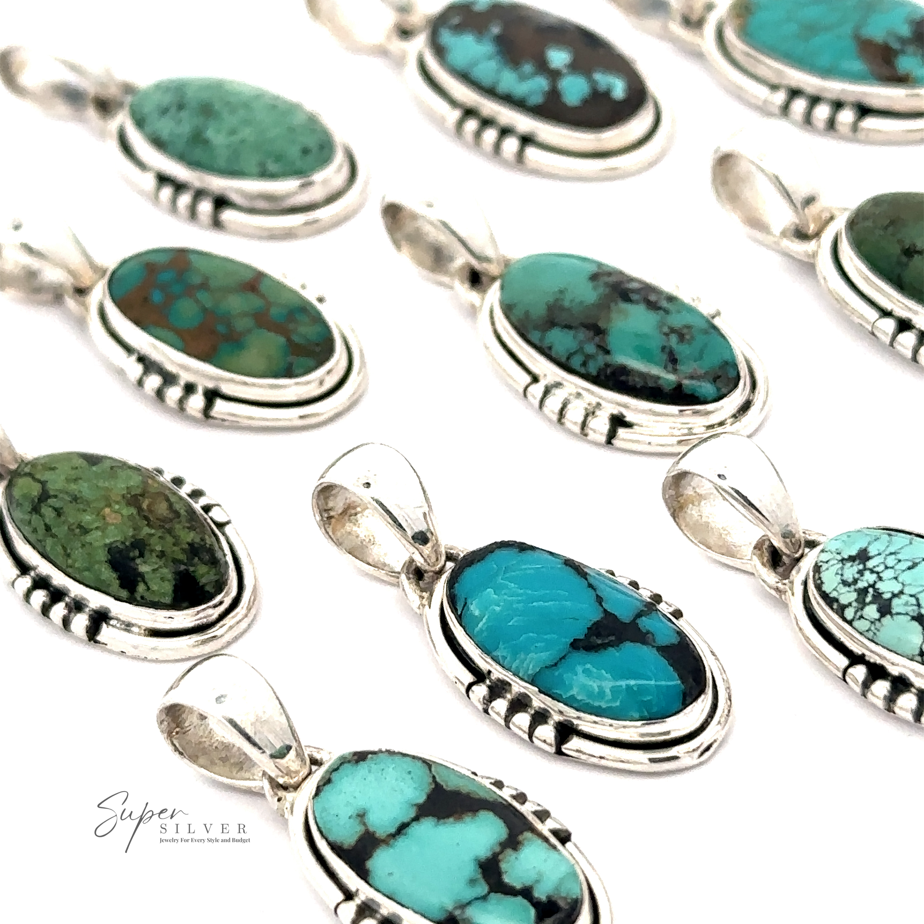 Several Natural Turquoise Elongated Oval Pendants encased in handmade .925 sterling silver settings are displayed on a white surface, arranged neatly. The 'Super Silver' logo is visible in the bottom left corner.