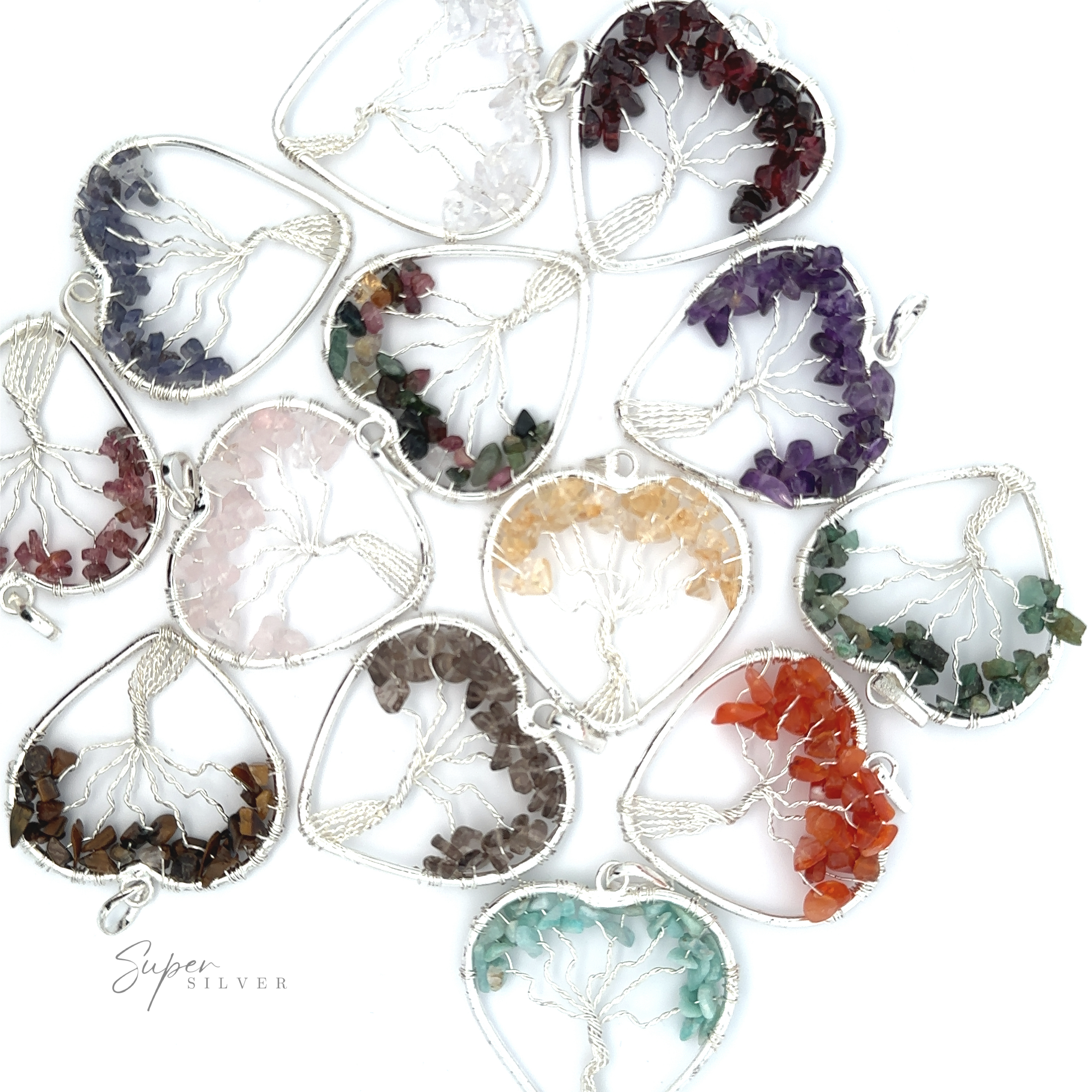 Various Heart Shaped Tree of Life Pendants are arranged in a semi-circle. Each pendant, featuring different colored stones, showcases a variety of gemstones and raw stone beads.