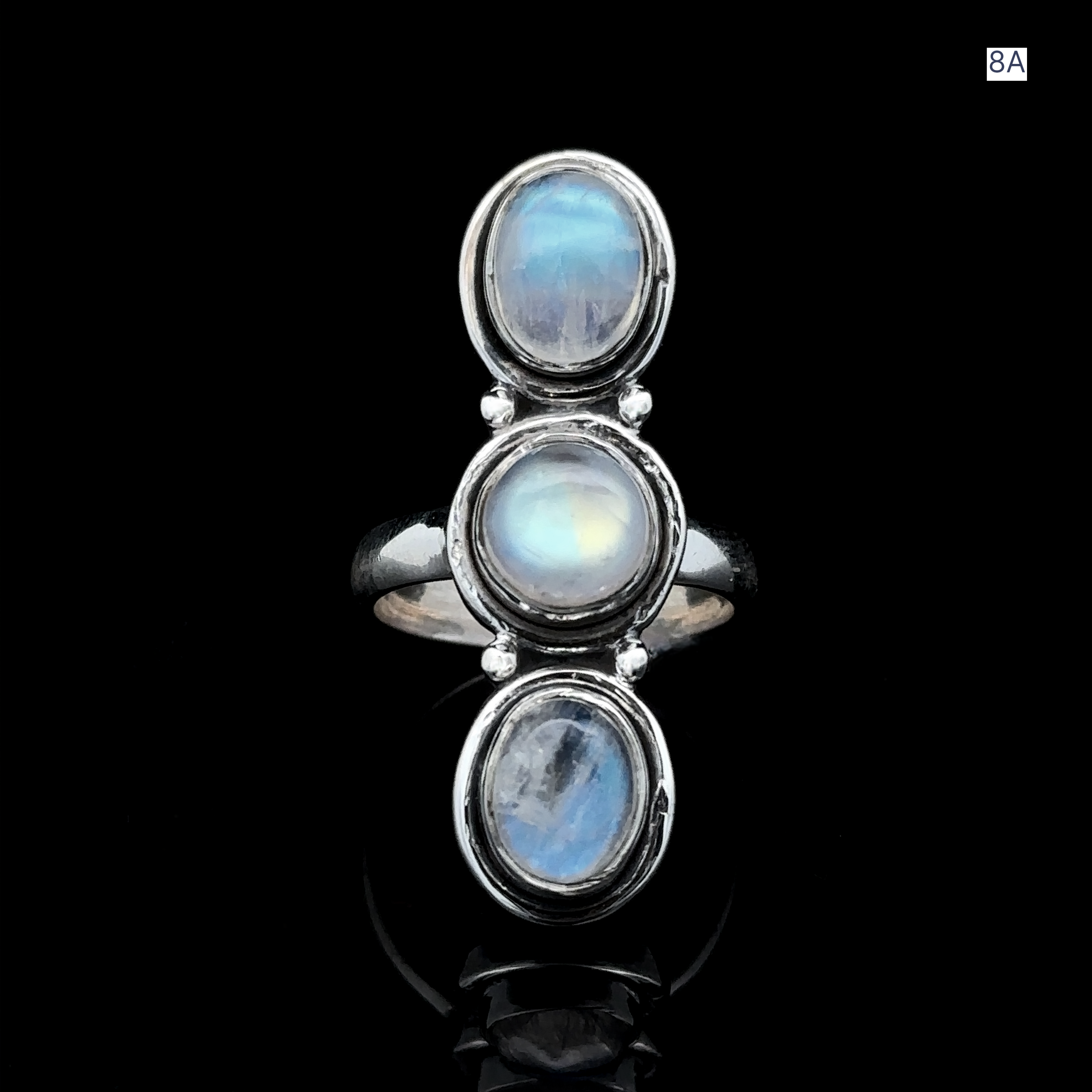 Triple Moonstone Ring crafted from sterling silver, showcases three stacked oval cabochons set on a polished black backdrop, exuding goddess energy.