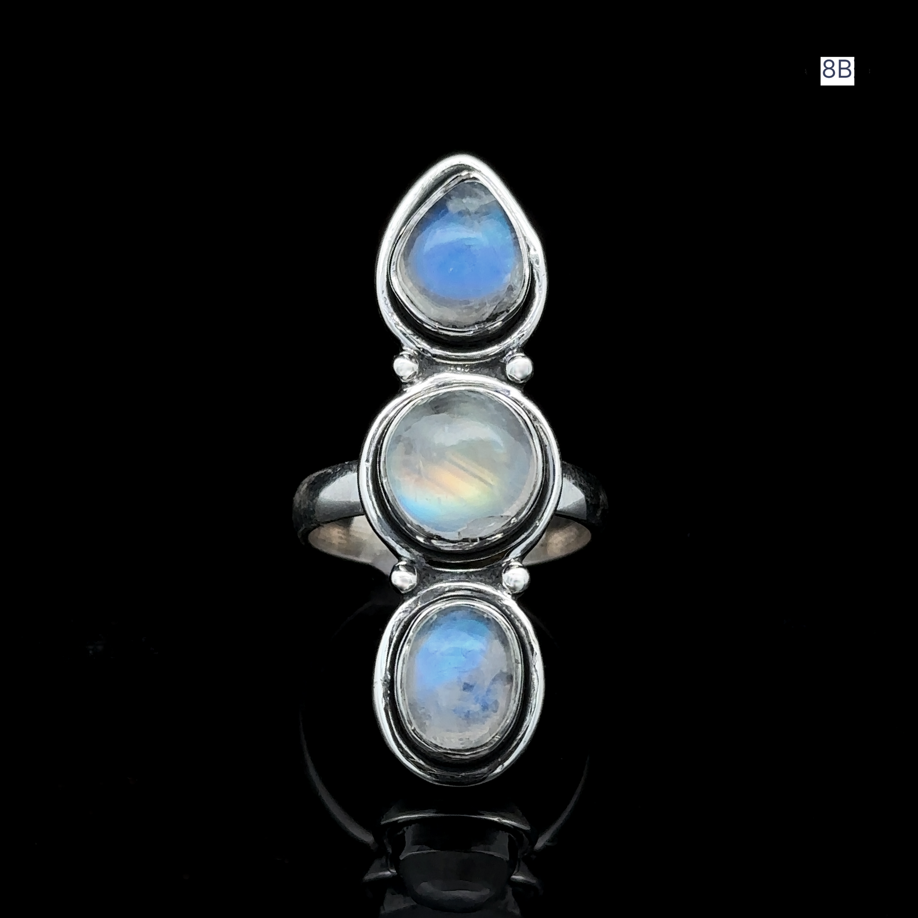 Introducing the Triple Moonstone Ring: a sterling silver masterpiece featuring three oval moonstones stacked vertically, set against a black background to channel goddess energy.