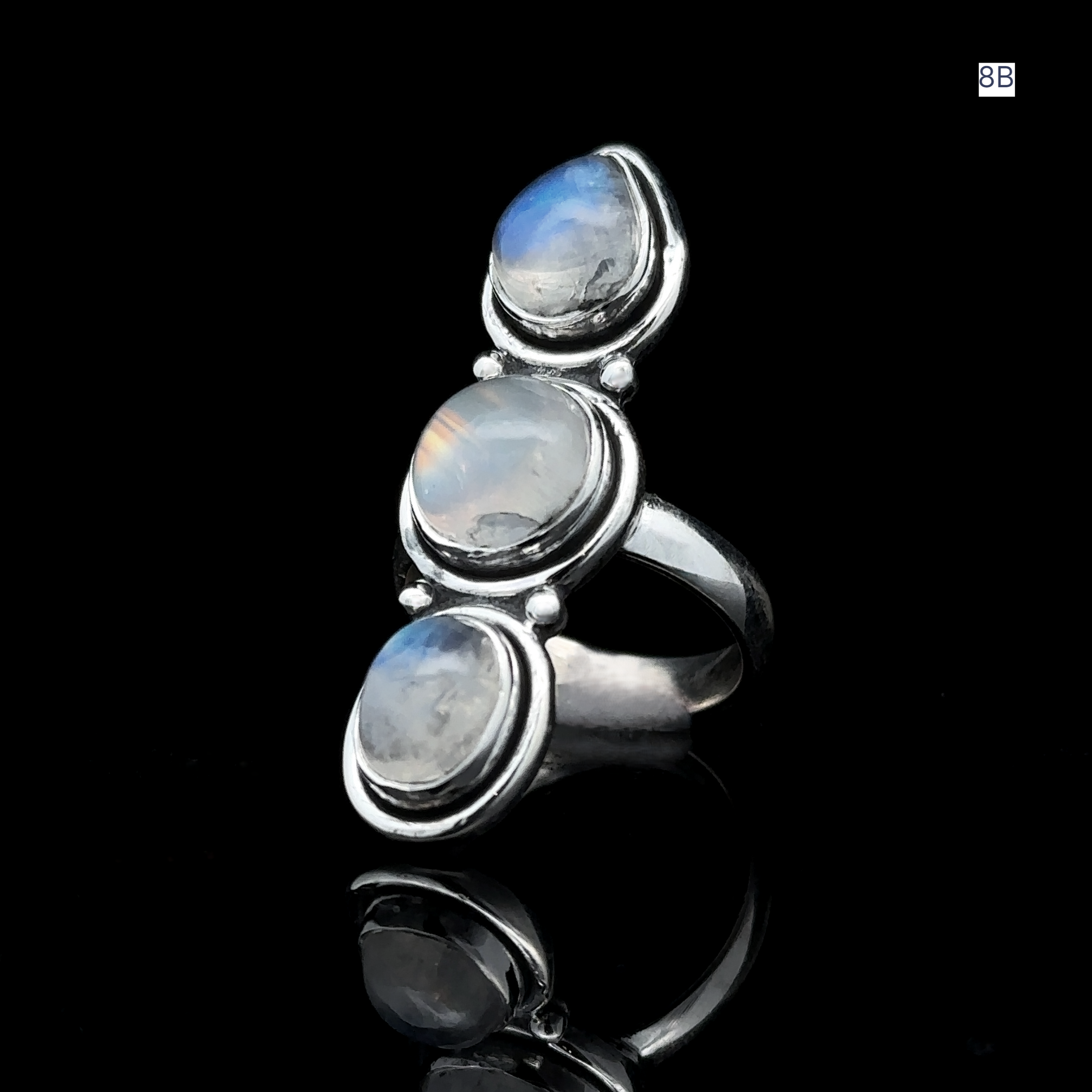The Triple Moonstone Ring is crafted from sterling silver and features three oval moonstones arranged vertically on a dark backdrop, radiating powerful goddess energy.