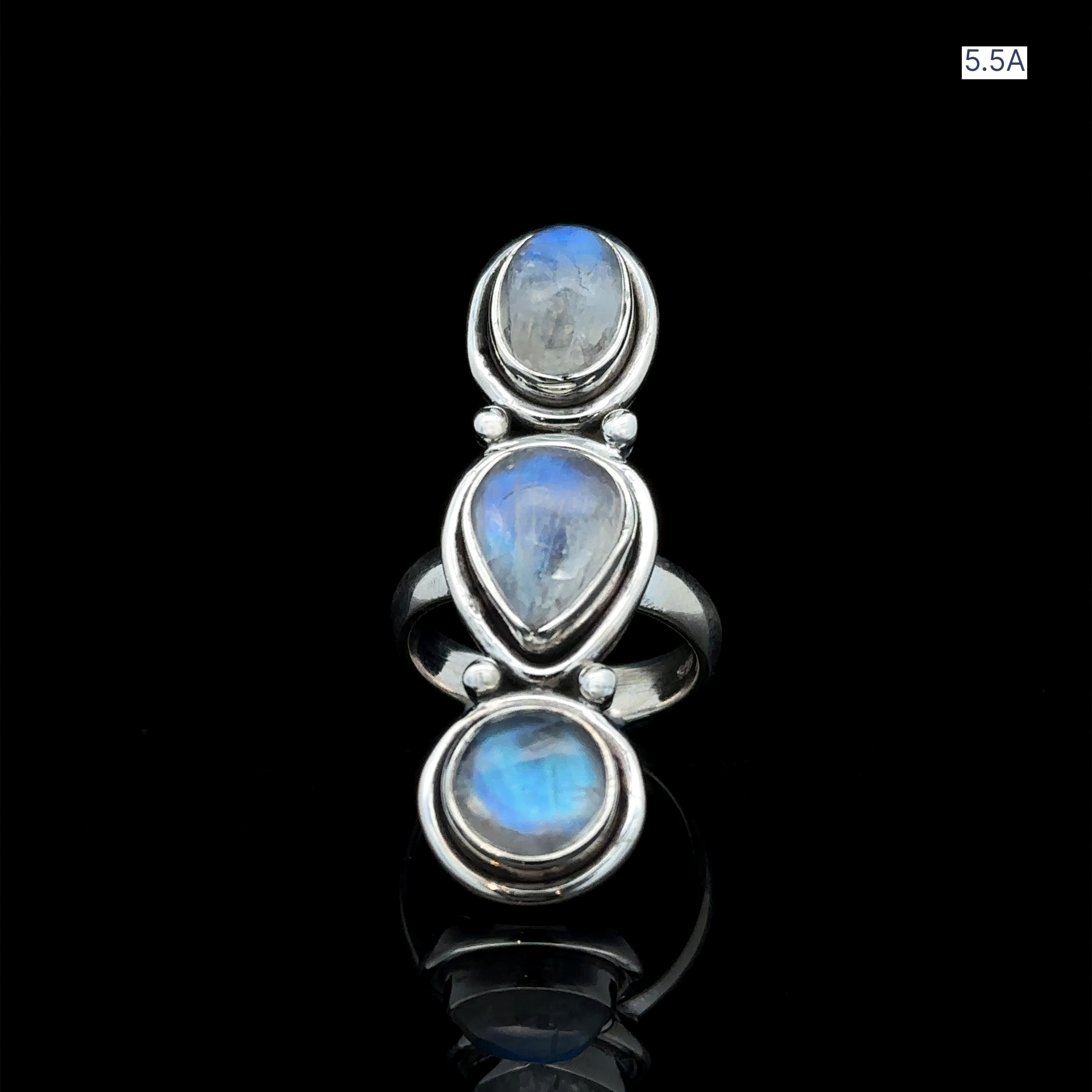 The Triple Moonstone Ring showcases three blue moonstone gems arranged vertically on a sleek black background, channeling goddess energy.