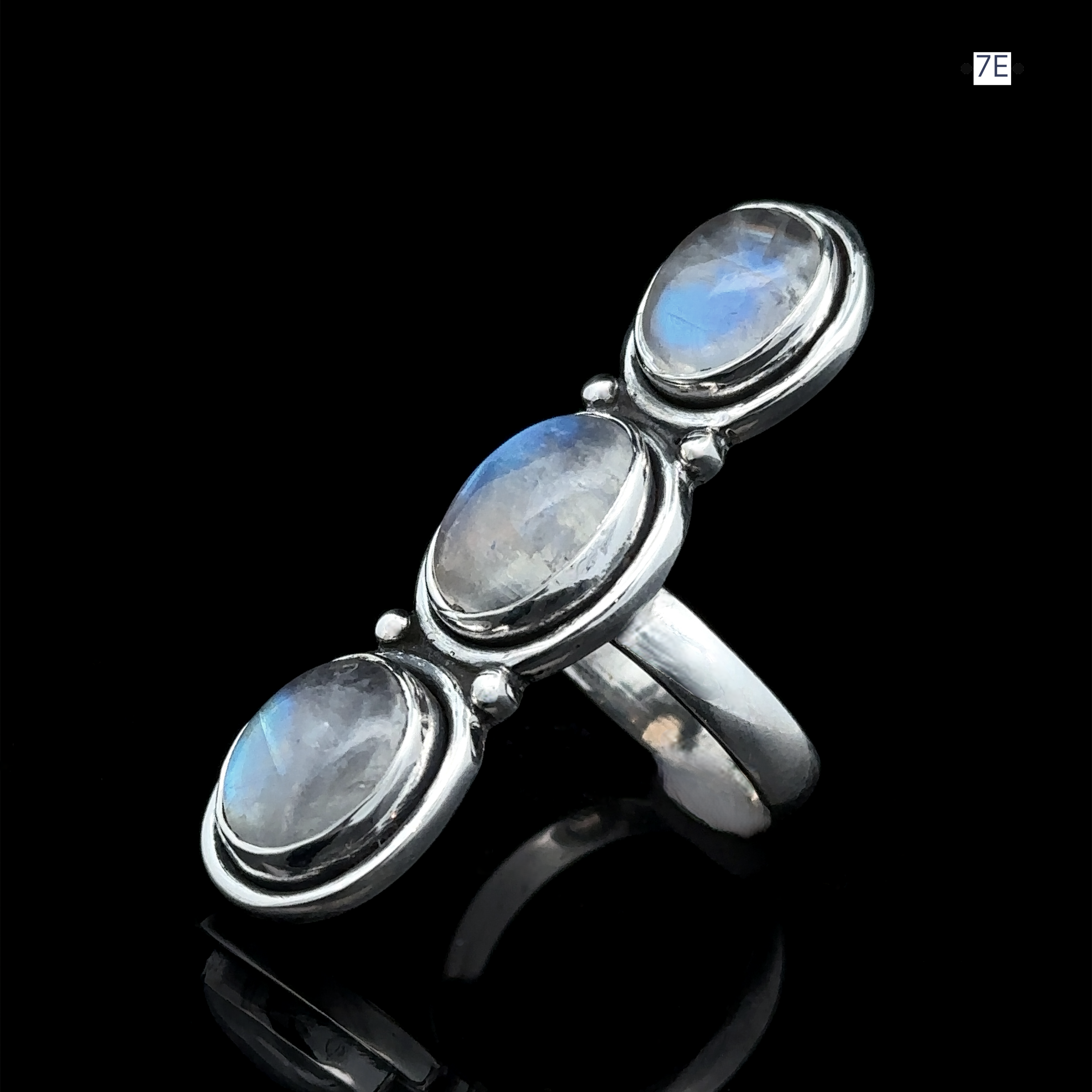 The Triple Moonstone Ring showcases three oval moonstones set against a black backdrop, emanating powerful goddess energy.
