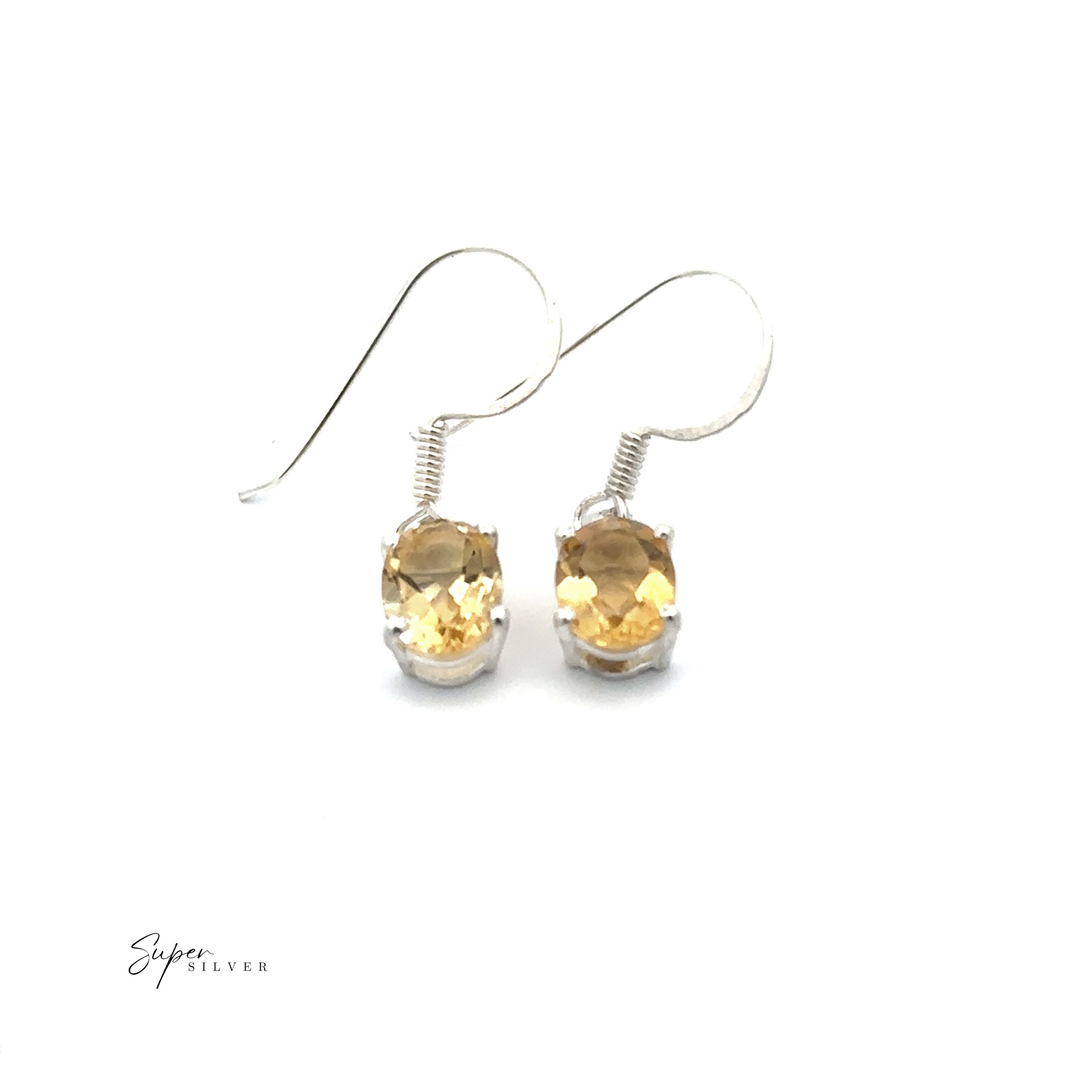 Brilliant Oval Gemstone Earrings: Sterling silver earrings featuring oval-cut yellow gemstones in prong settings, shown on a white background.