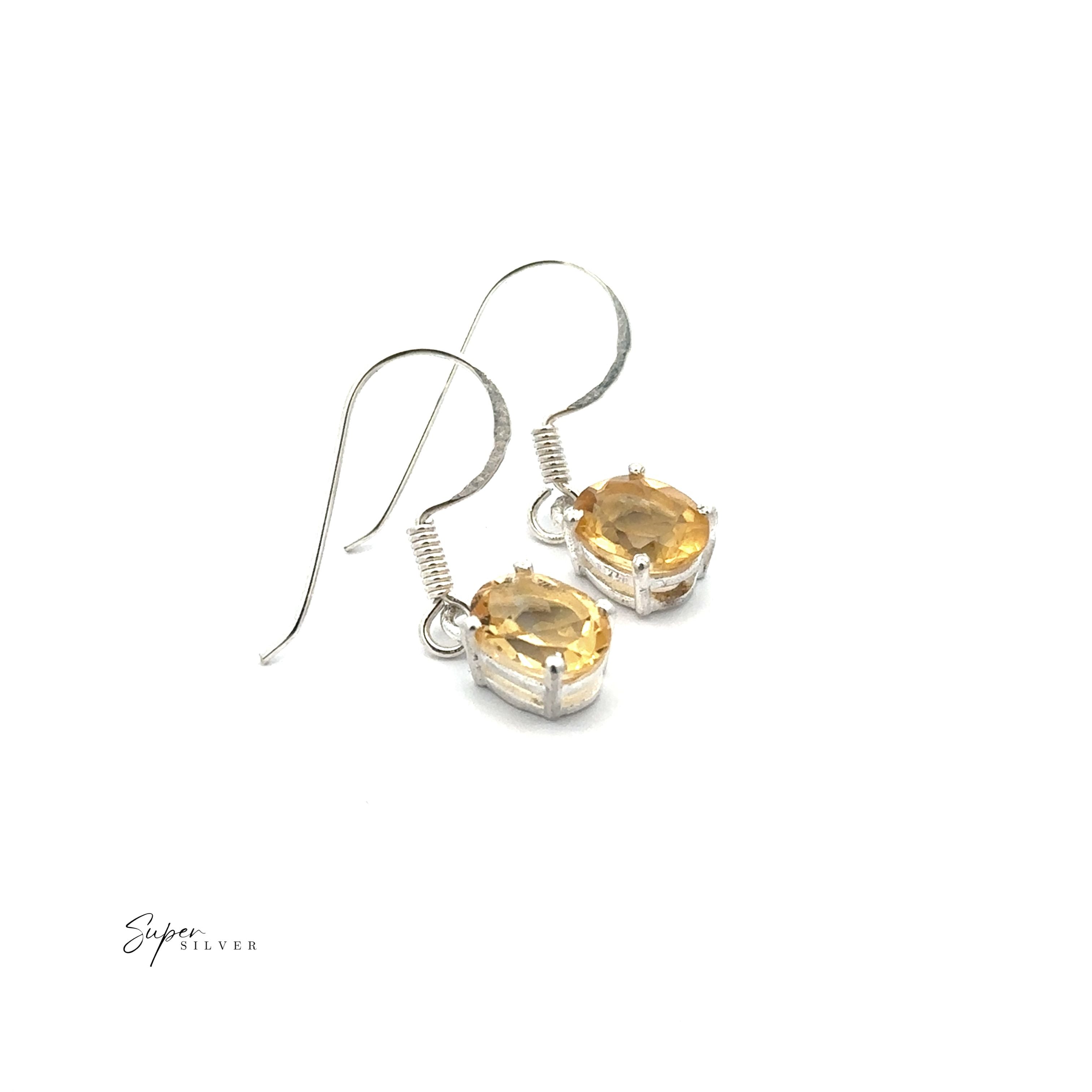 Brilliant Oval Gemstone Earrings: Sterling silver hook earrings each showcase an oval faceted yellow gemstone in a prong setting, displayed on a white background.