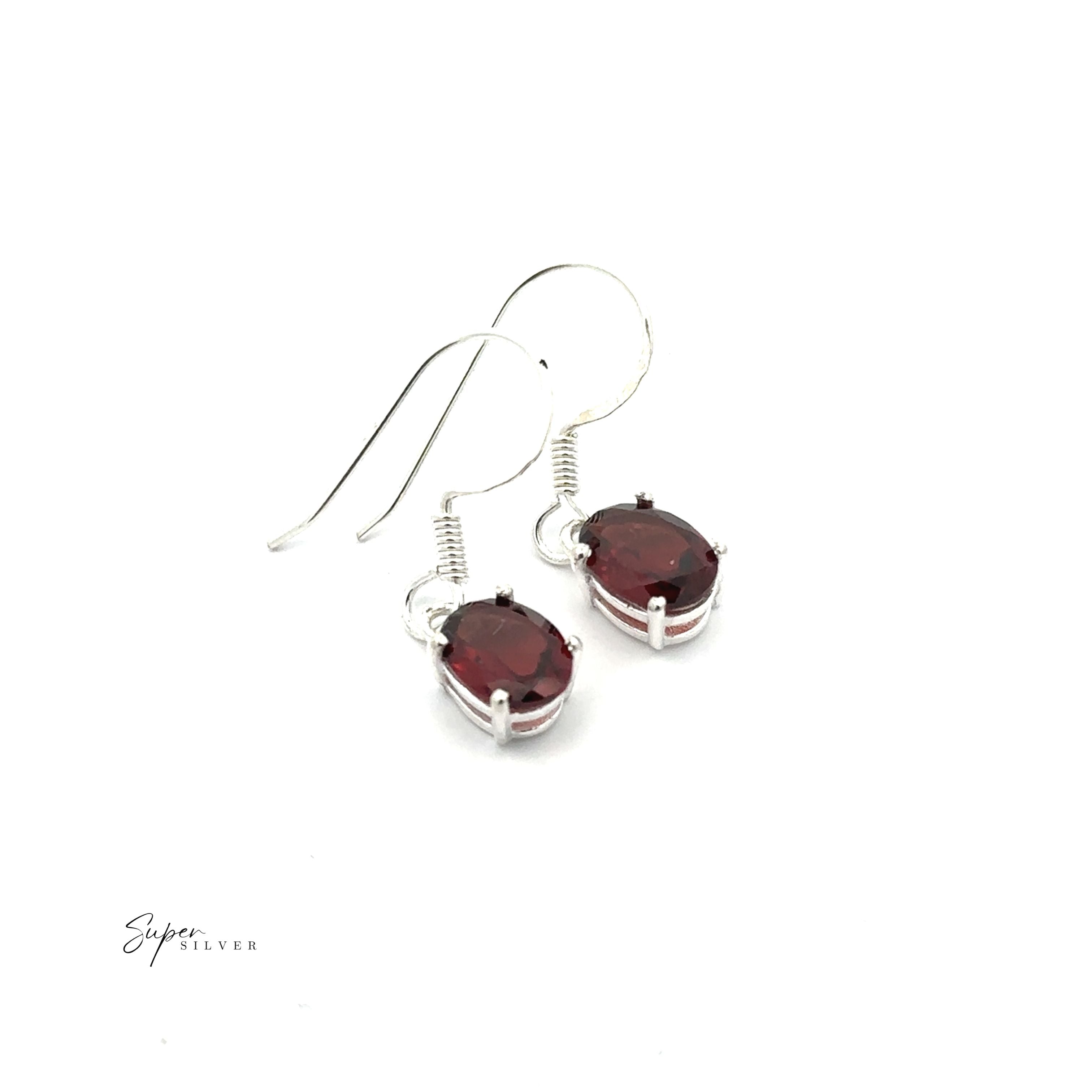Brilliant Oval Gemstone Earrings: Sterling silver earrings featuring oval-shaped red gemstones, prong-set for elegance, shown on a white background.