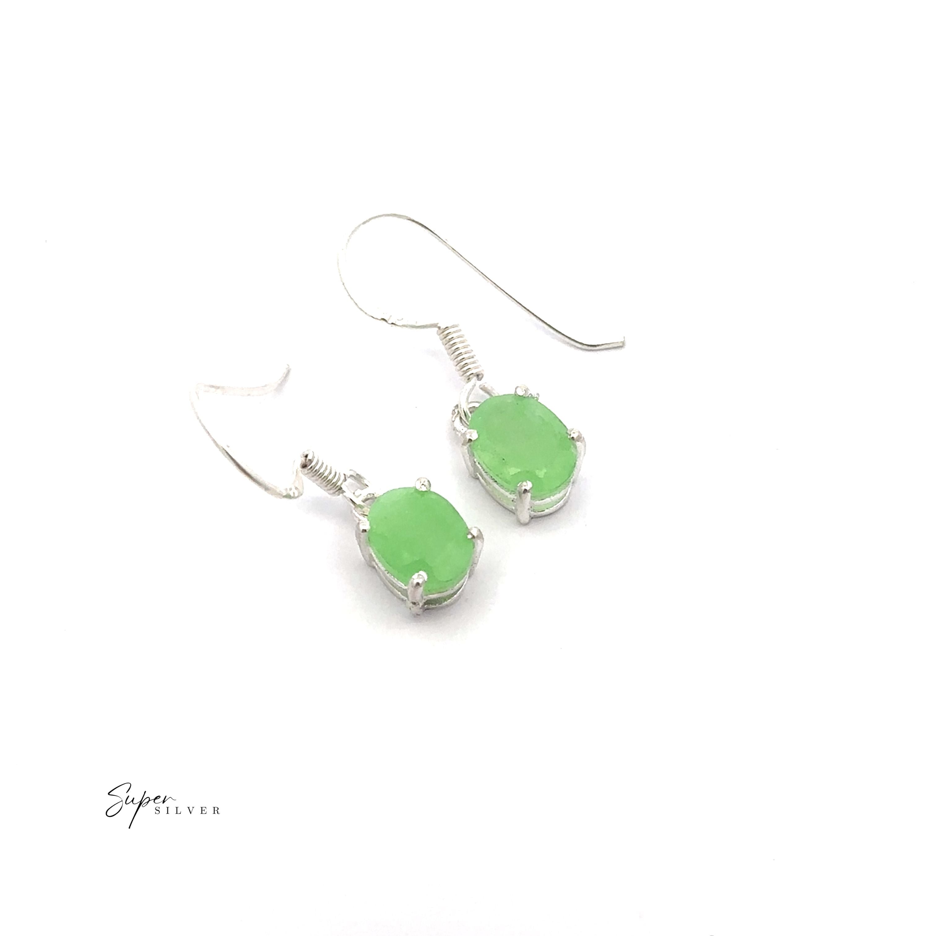 The Brilliant Oval Gemstone Earrings are sterling silver hook earrings with oval green gemstones in prong settings, shown on a white background.
