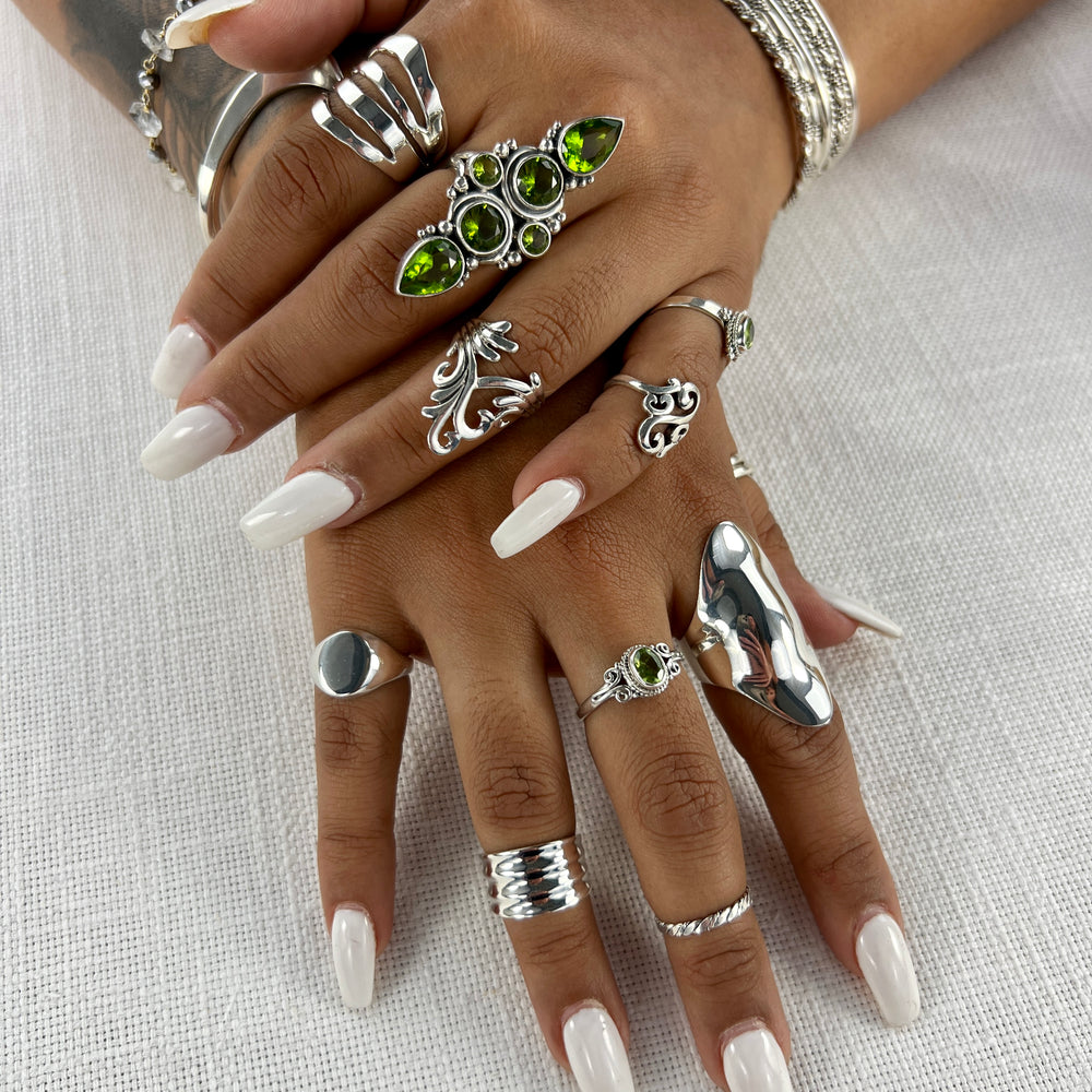 
                  
                    A woman's hands adorned with a beautiful Exquisite Peridot Statement Ring and a stunning silver ring.
                  
                
