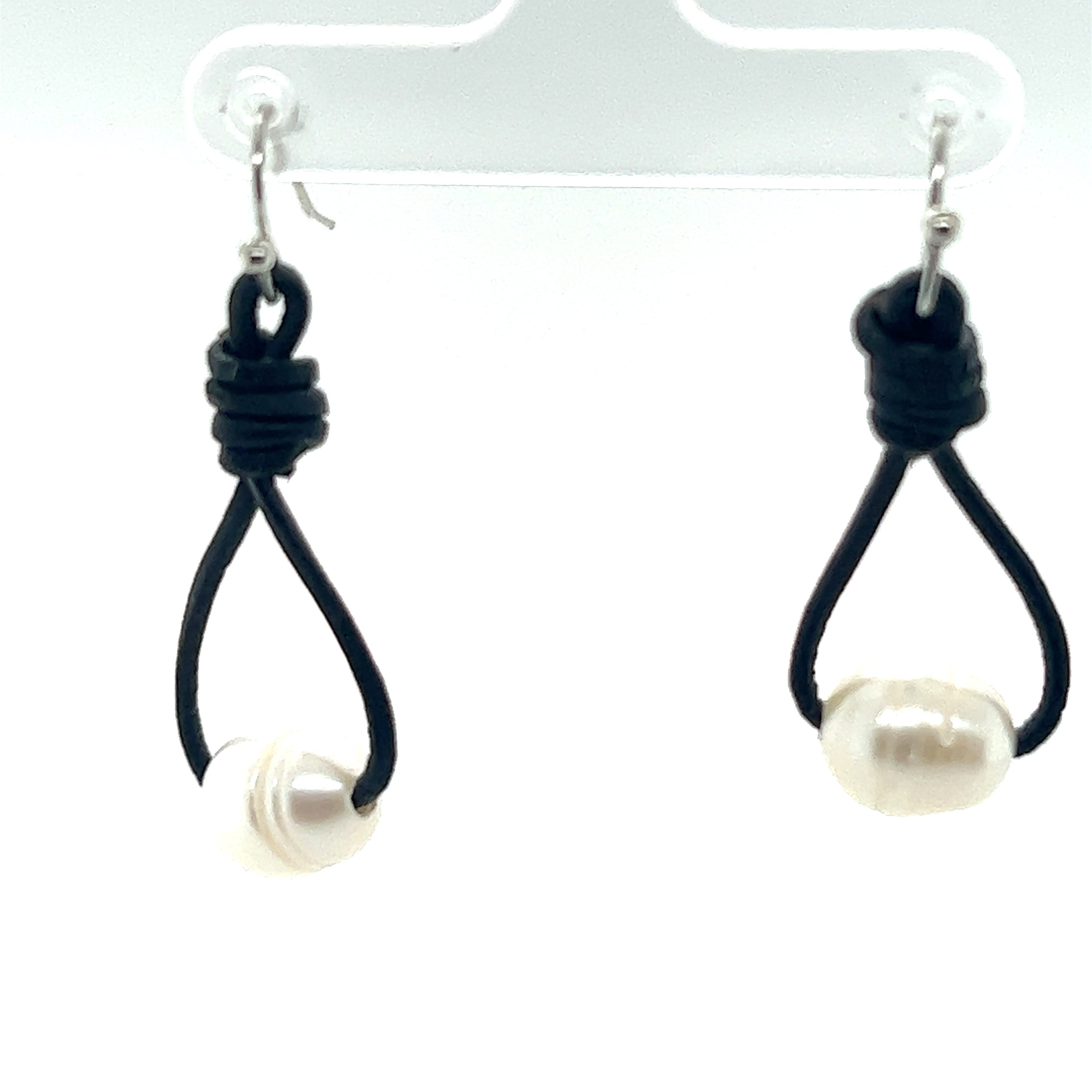 A pair of Super Silver Leather Cord and Pearl Earrings, perfect for a laid-back style.