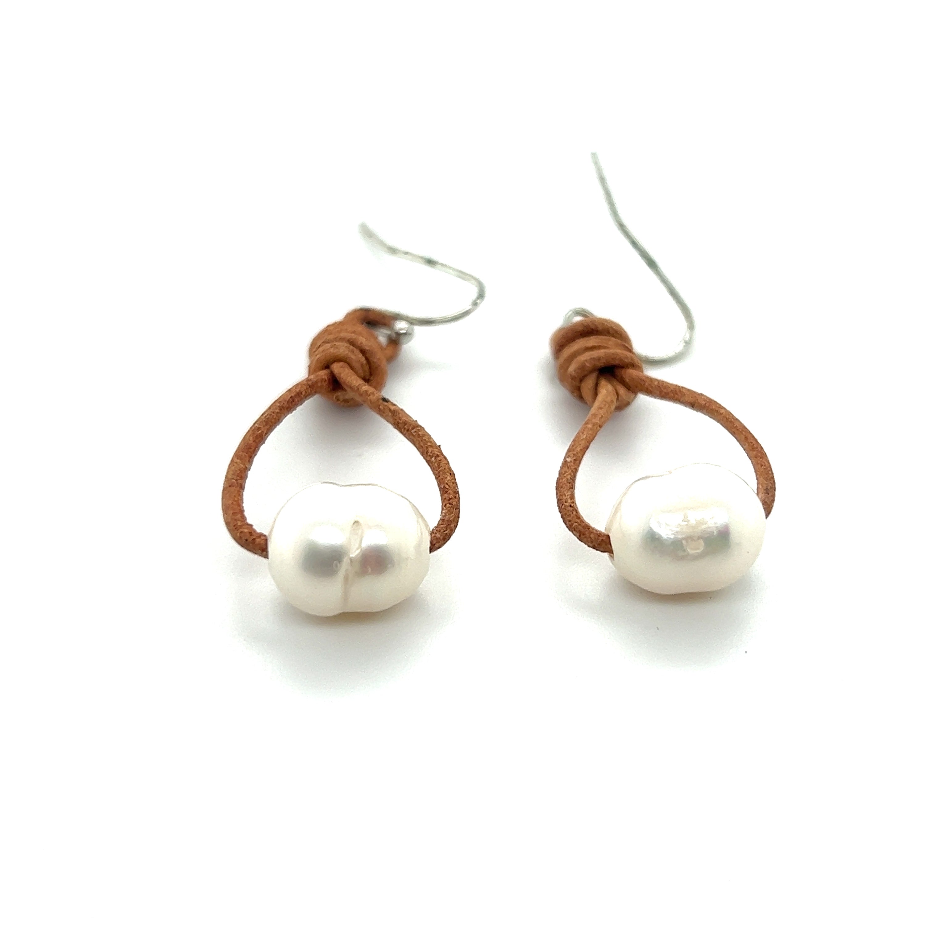 A pair of Super Silver Leather Cord and Pearl Earrings on a white background.