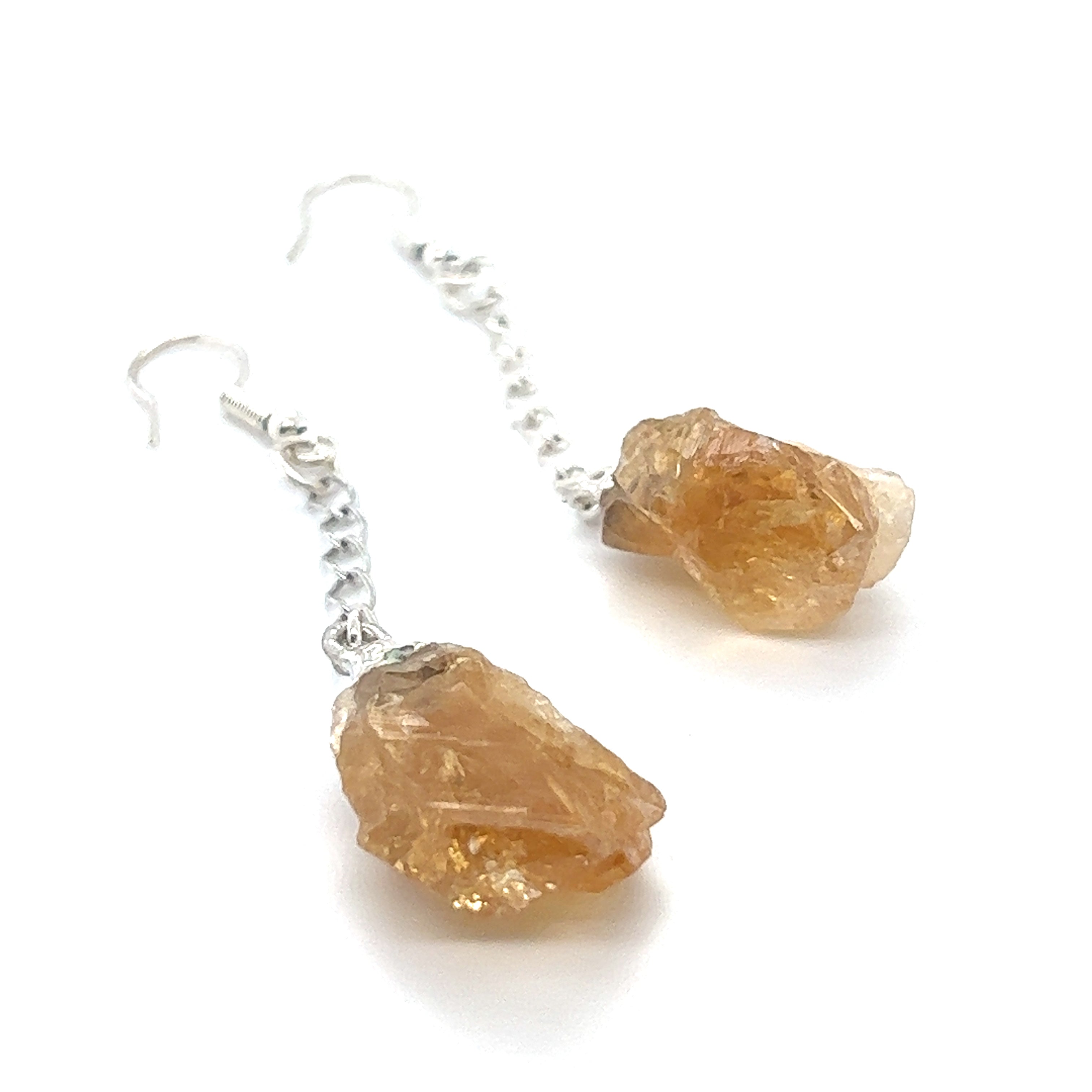 A pair of Super Silver Long Crystal Earrings With Chain with raw orange crystals hanging from a delicate chain.