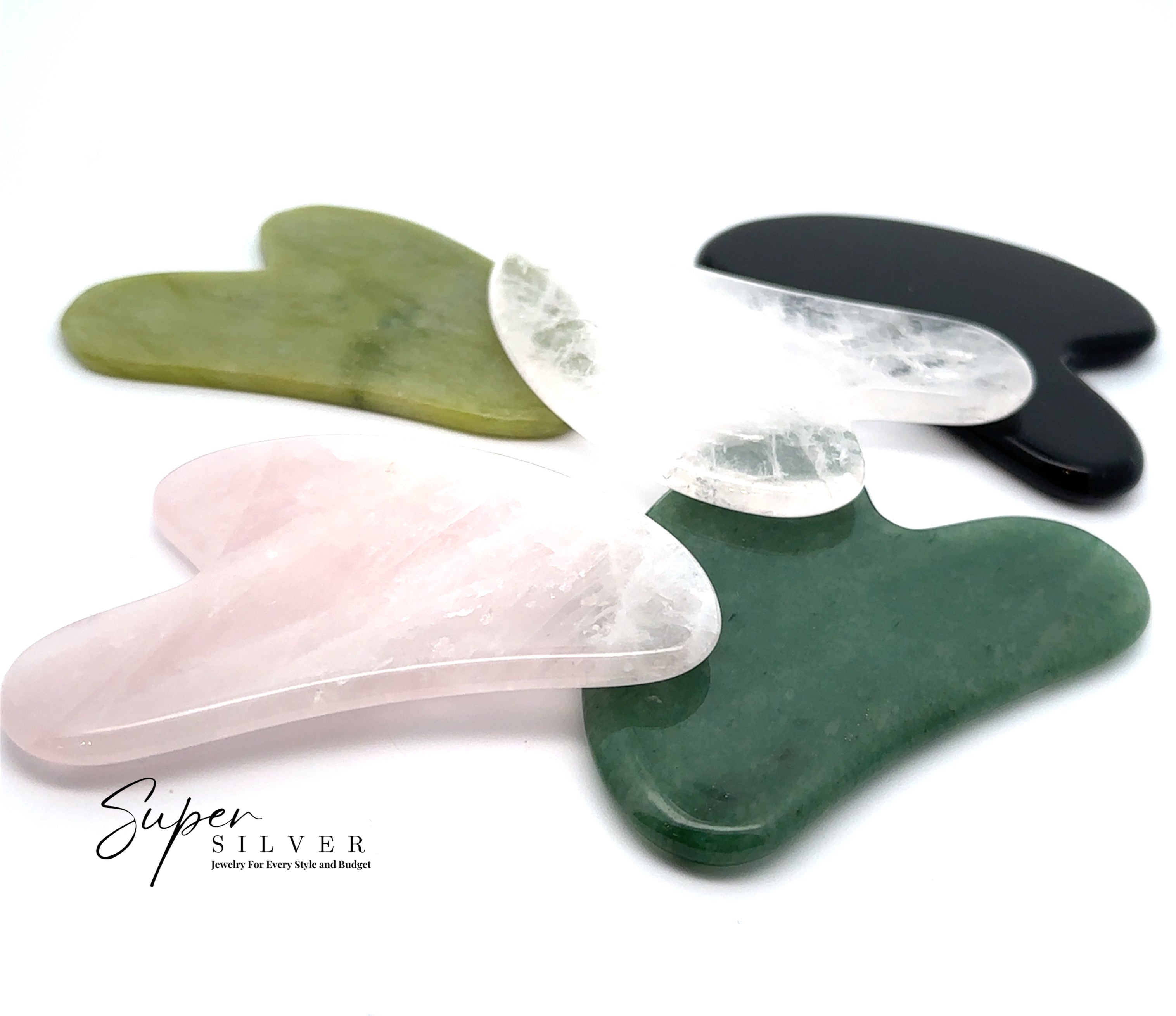 Five Stone Gua Sha massage tools in green, pink, white, and black genuine gemstones overlap on a white background. The Super Silver logo appears at the bottom left—ideal for your self-care routine.