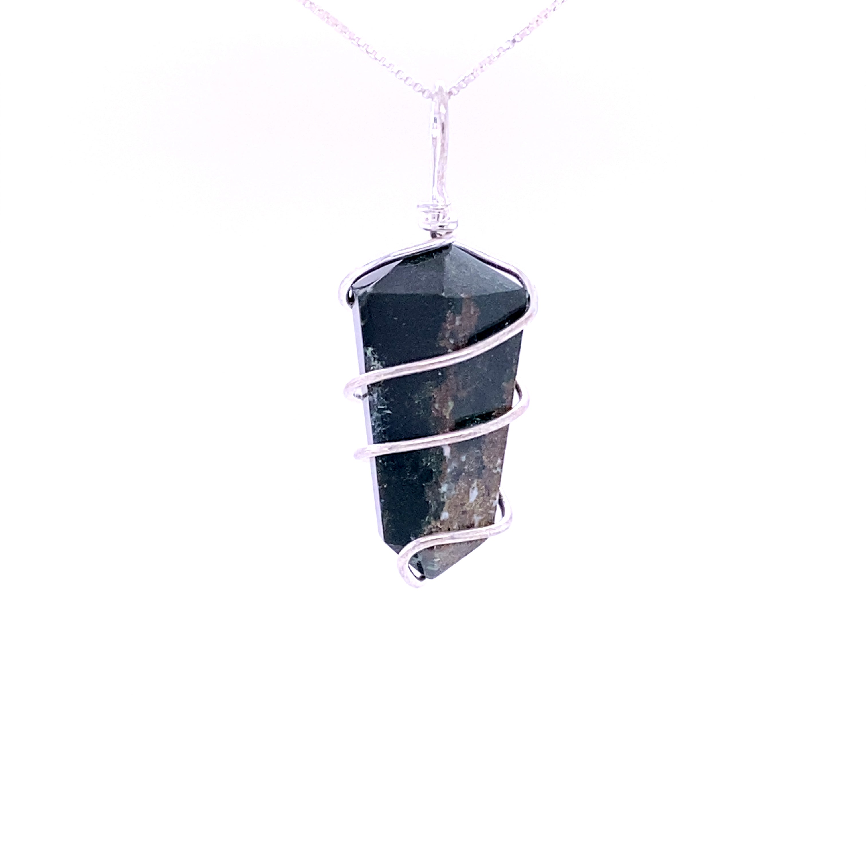 The Wire Wrapped Stone Pendant showcases a genuine dark crystal, intricately wrapped in mixed metals, suspended elegantly from a delicate silver chain.