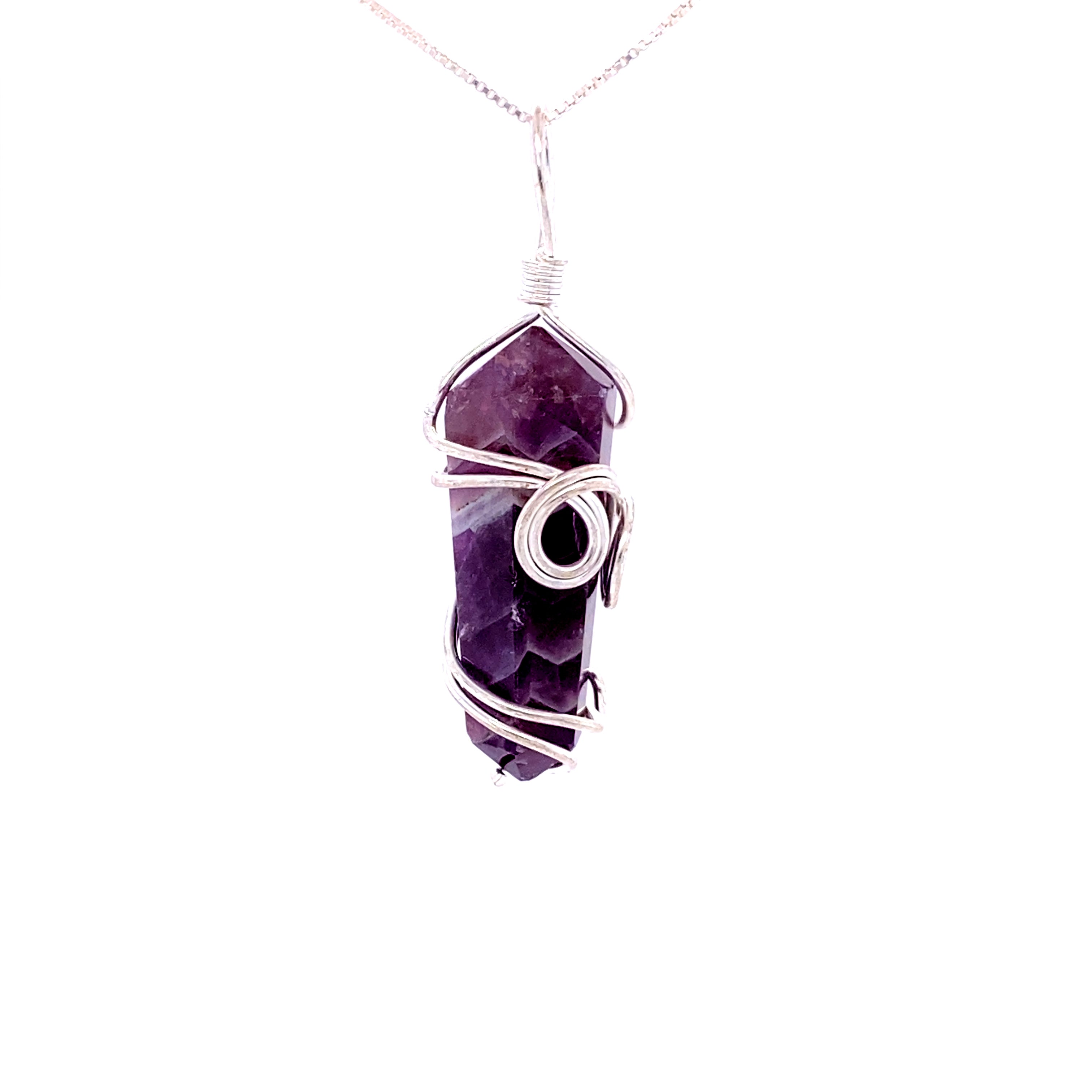The Wire Wrapped Stone Pendant is a genuine stone necklace featuring a purple crystal pendant intricately wrapped in silver wire, suspended on a thin chain.