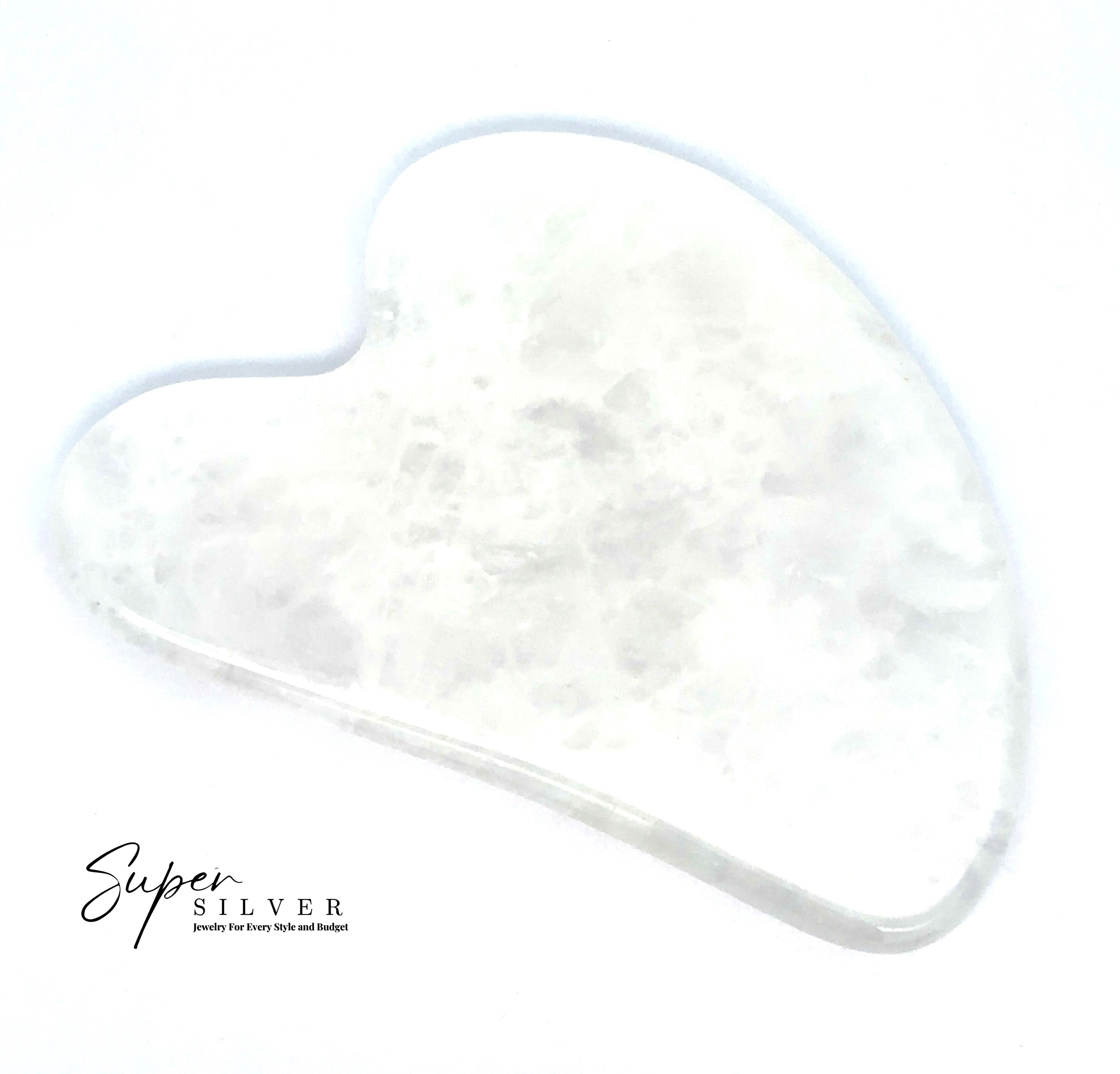 A white, heart-shaped Stone Gua Sha rests on a plain background with "Super Silver" text in the lower left corner—ideal for daily self-care routines.