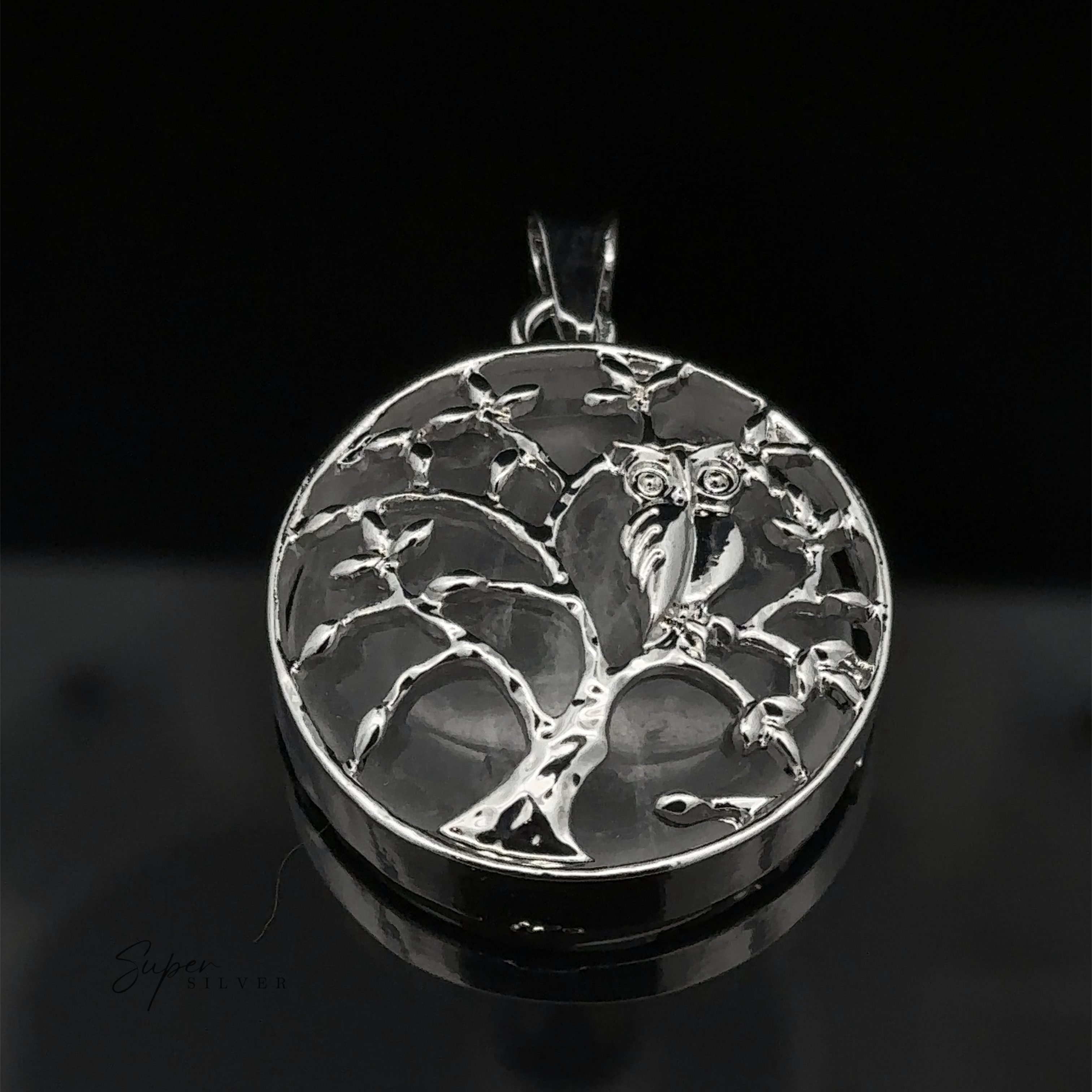 A stunning silver Owl and Tree Pendant featuring an intricate tree design with an owl perched on a branch, set against a black background. The mixed metals add depth and character to this exquisite piece.