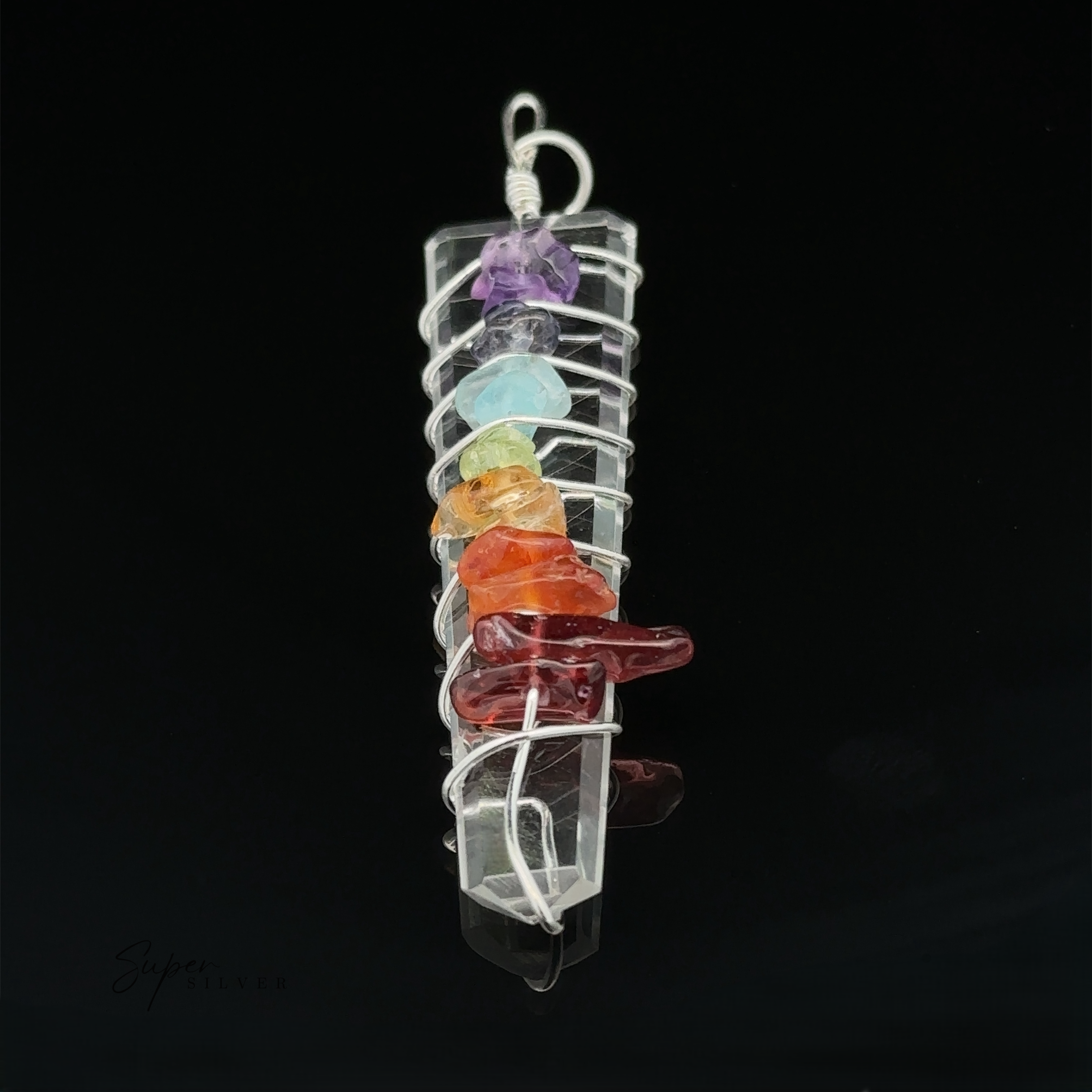 A Stone Slab Wire-Wrapped Chakra Pendant featuring a vertically aligned clear crystal wrapped in silver wire, adorned with seven chakra stones, creating an exquisite example of crystal pendants.
