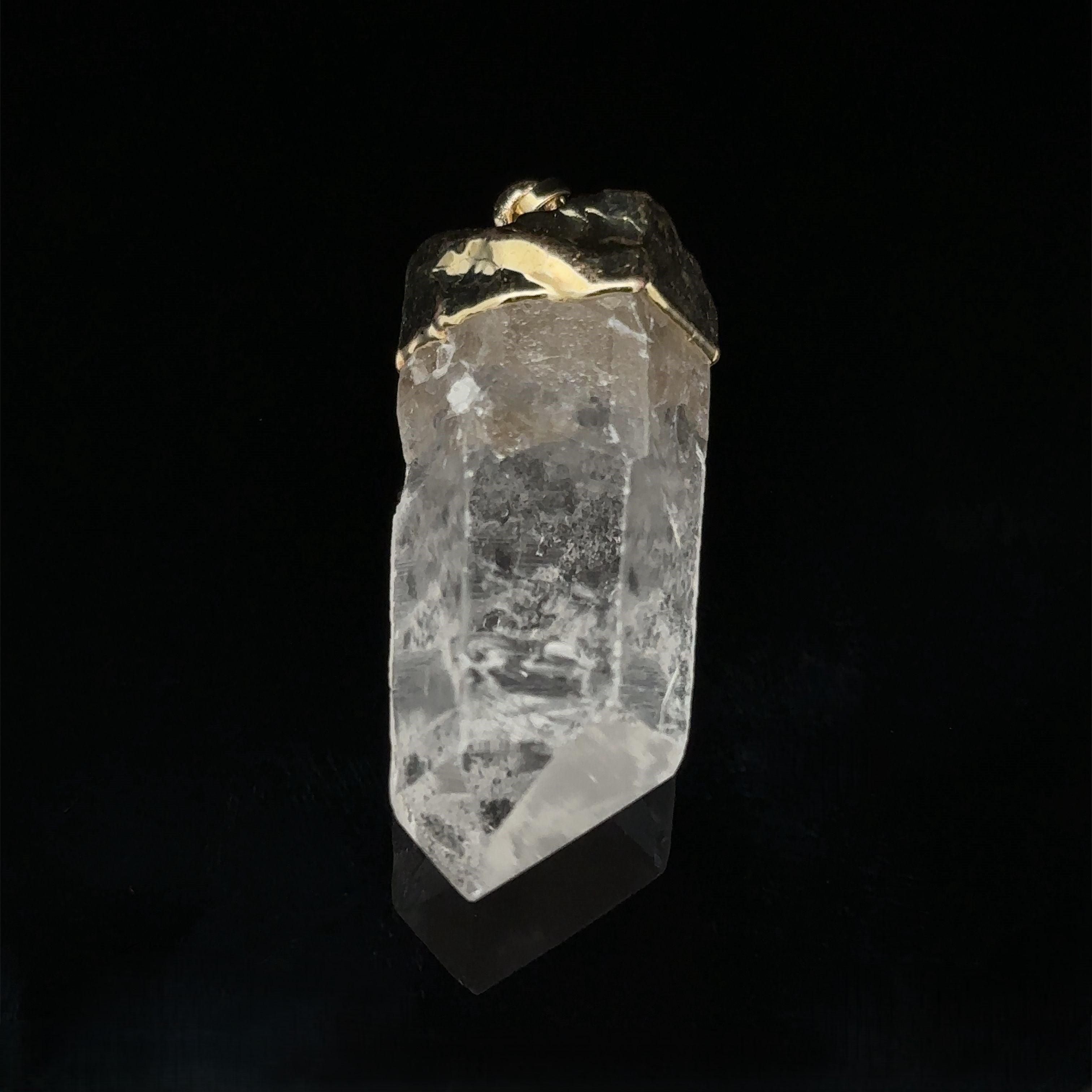A Raw Crystal Pendant With Gold Cap forming a stunning natural gemstone pendant against a black background.