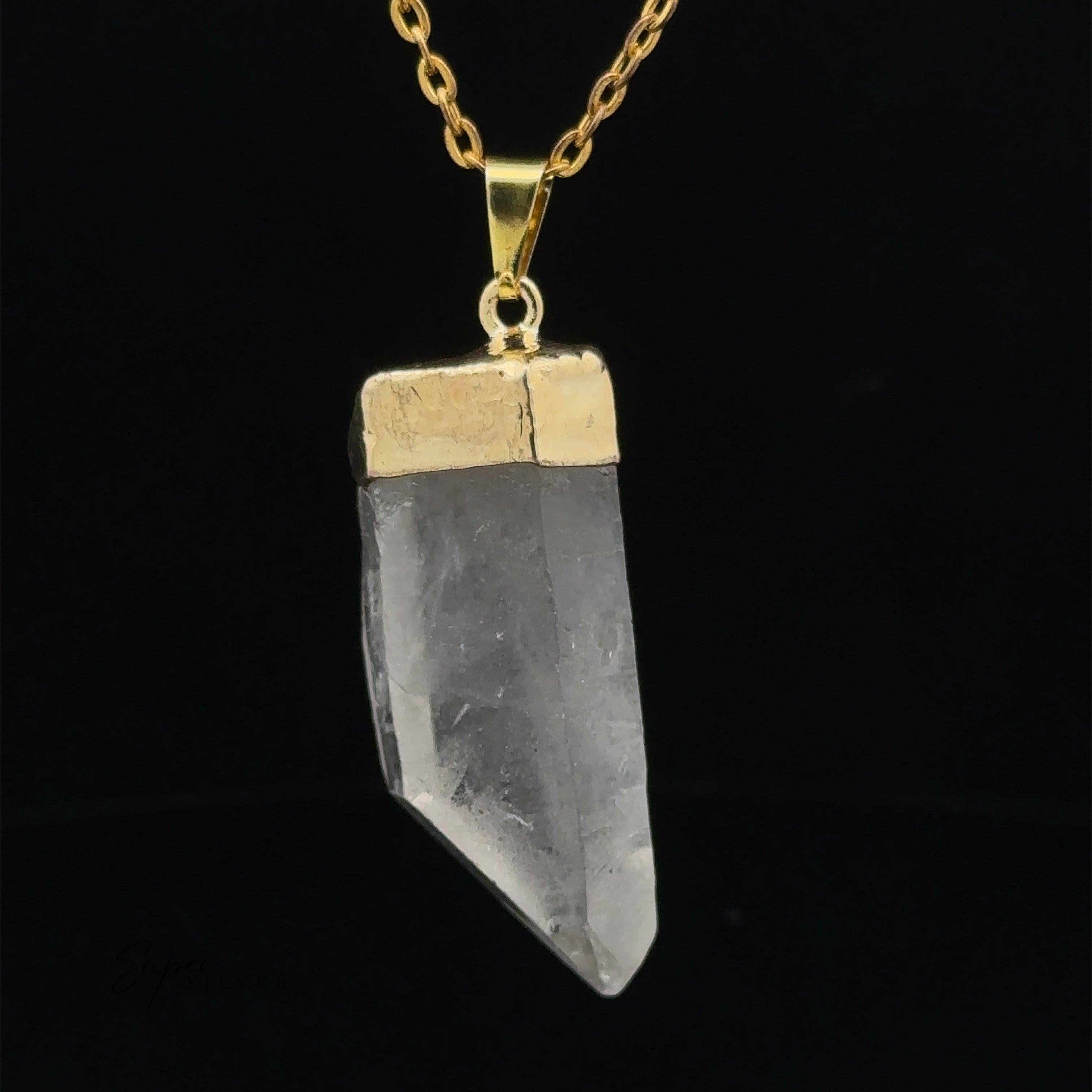 A Raw Crystal Pendant With Gold Cap. The background is black.