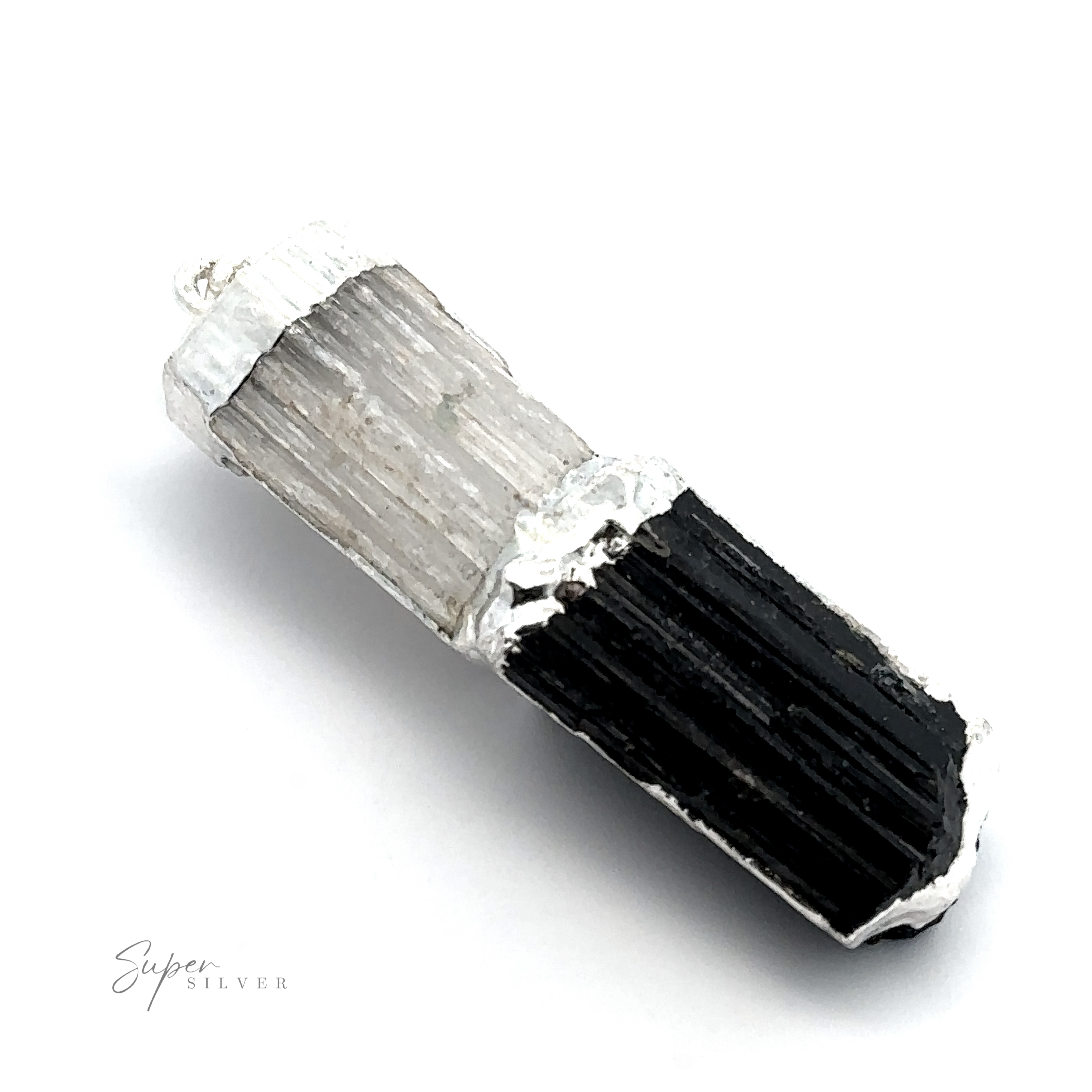 A black and white bi-colored crystal pendant with a textured surface, laying on a white background. The words "Super Silver" are lightly visible in the bottom left corner. This stunning piece combines the protective properties of tourmaline with the healing energy of selenite, creating a truly unique accessory—Tourmaline and Selenite Pendant.