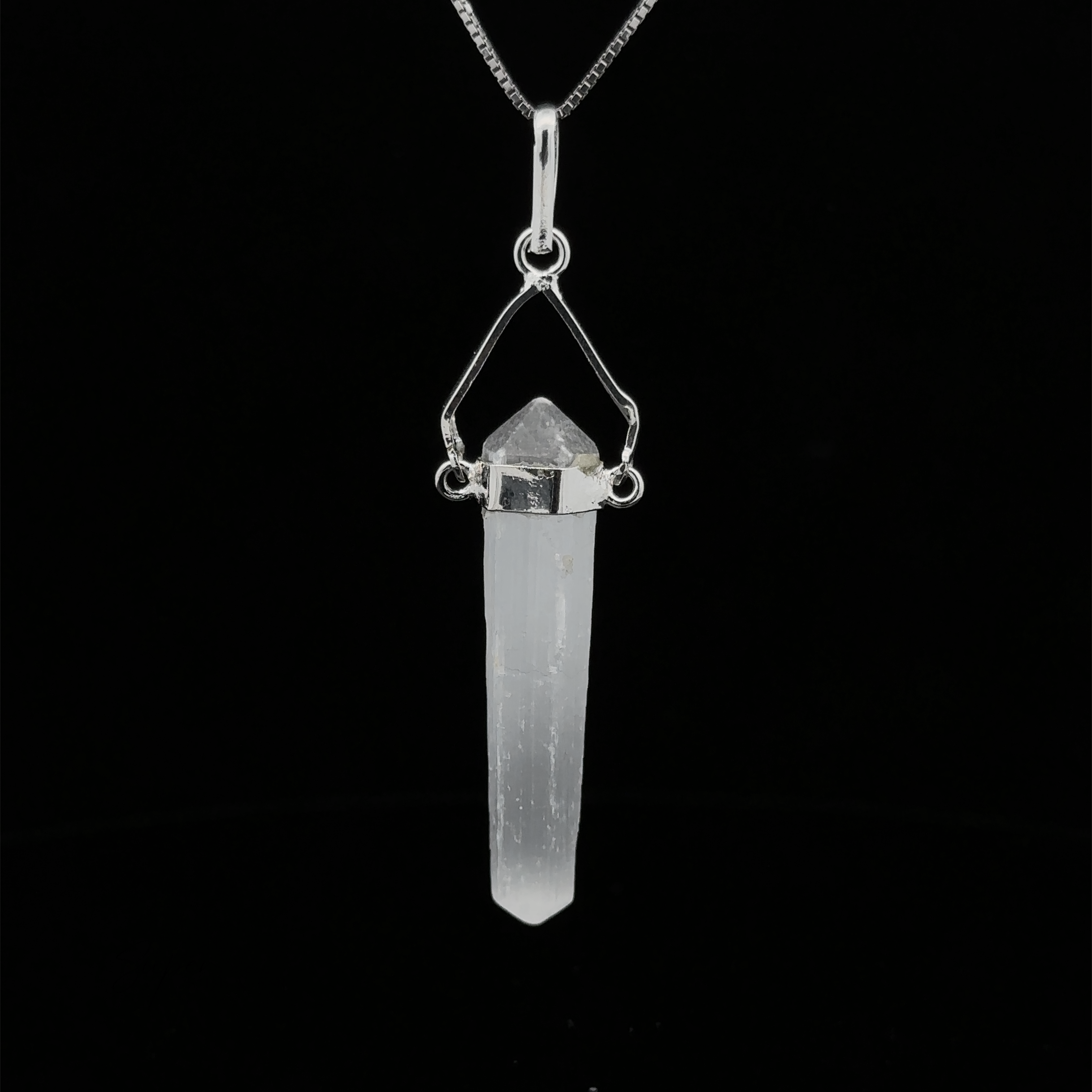 A Raw Stone Swivel Pendant featuring a clear crystal wrapped in a silver-plated setting, hanging from a silver chain, all set against a black background.