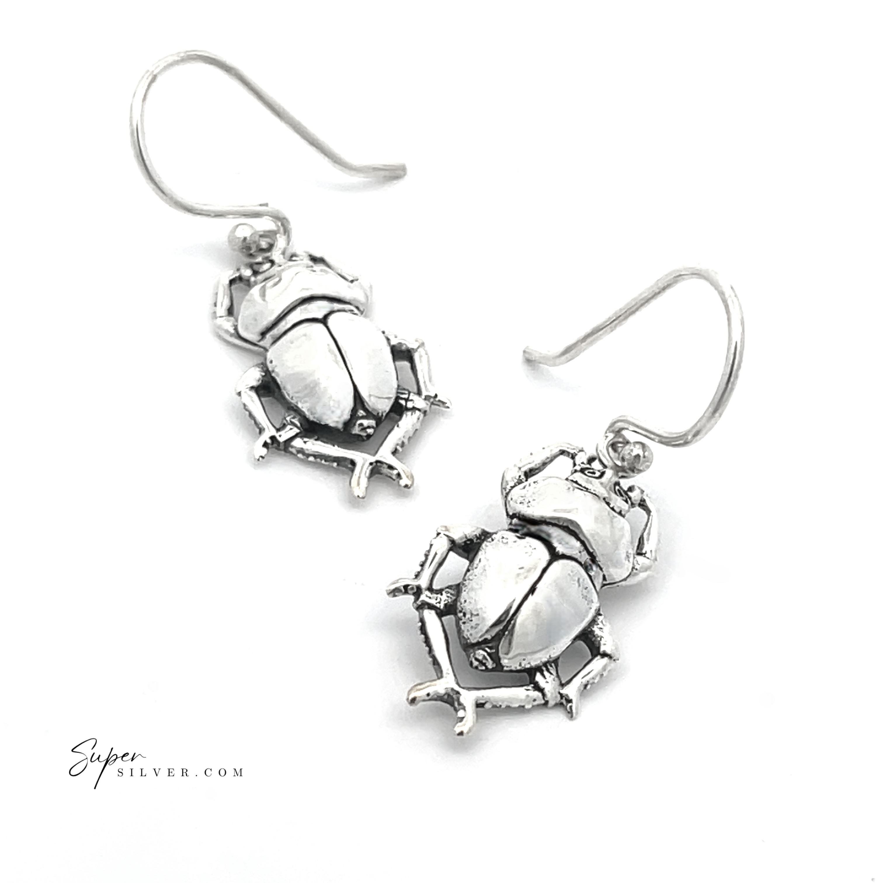 A pair of Beetle Earrings crafted from sterling silver, featuring scarab beetle designs with hooks on a white background, evoking the style of ancient Egyptian jewelry.