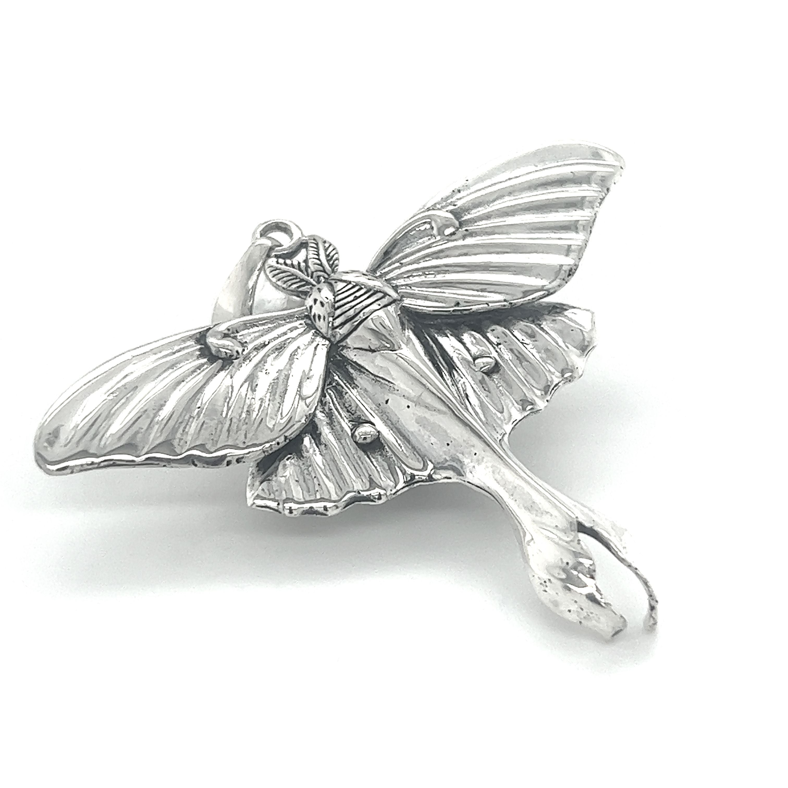 A Super Silver Statement Lunar Moth pendant on a white background, showcasing ethereal beauty and transformation.