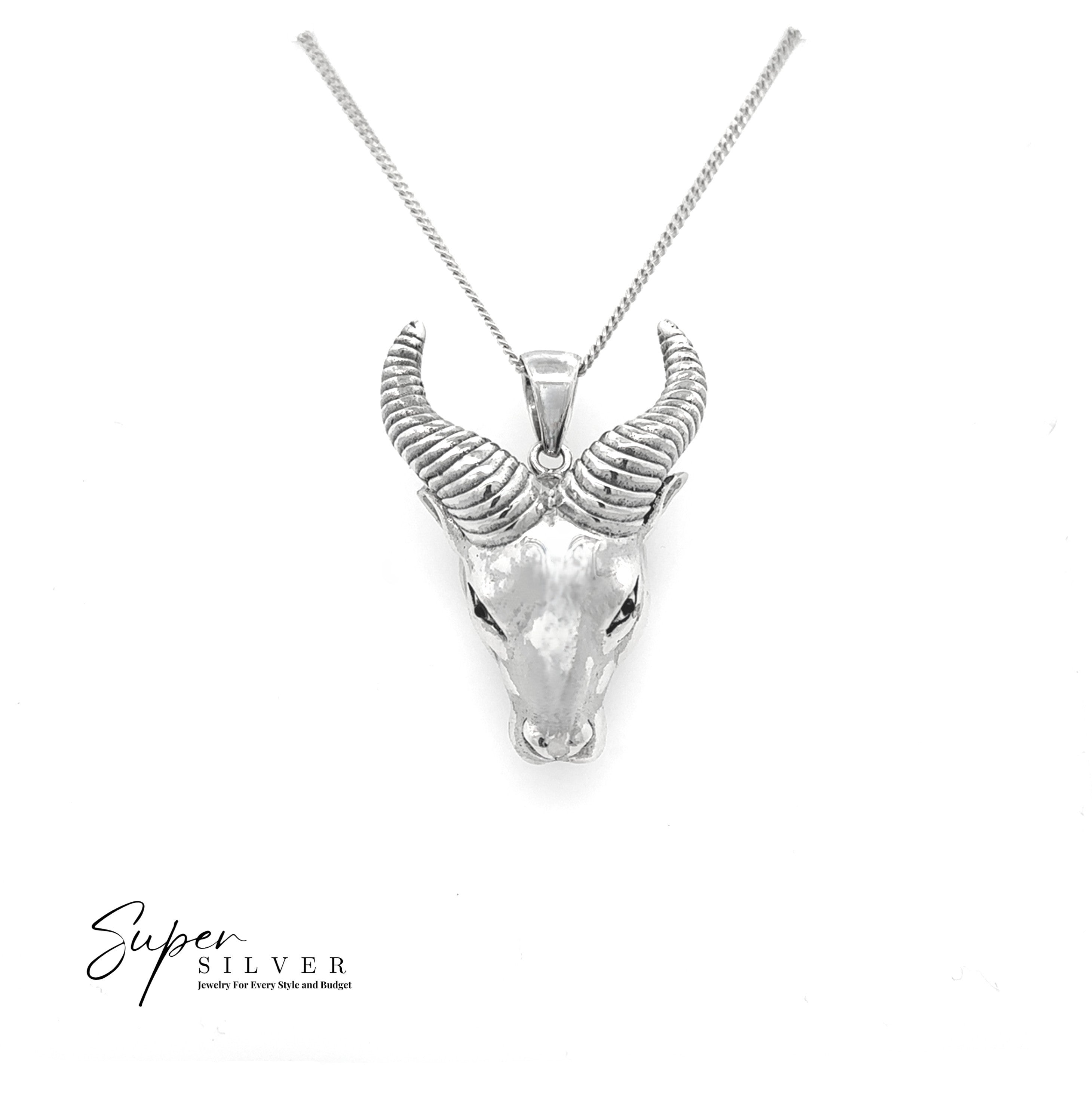 The Ram Statement Pendant is a silver necklace showcasing a sterling silver ram head with intricate curved horns, ideal for gothic jewelry enthusiasts. The "Super Silver" logo is displayed in the lower left corner.