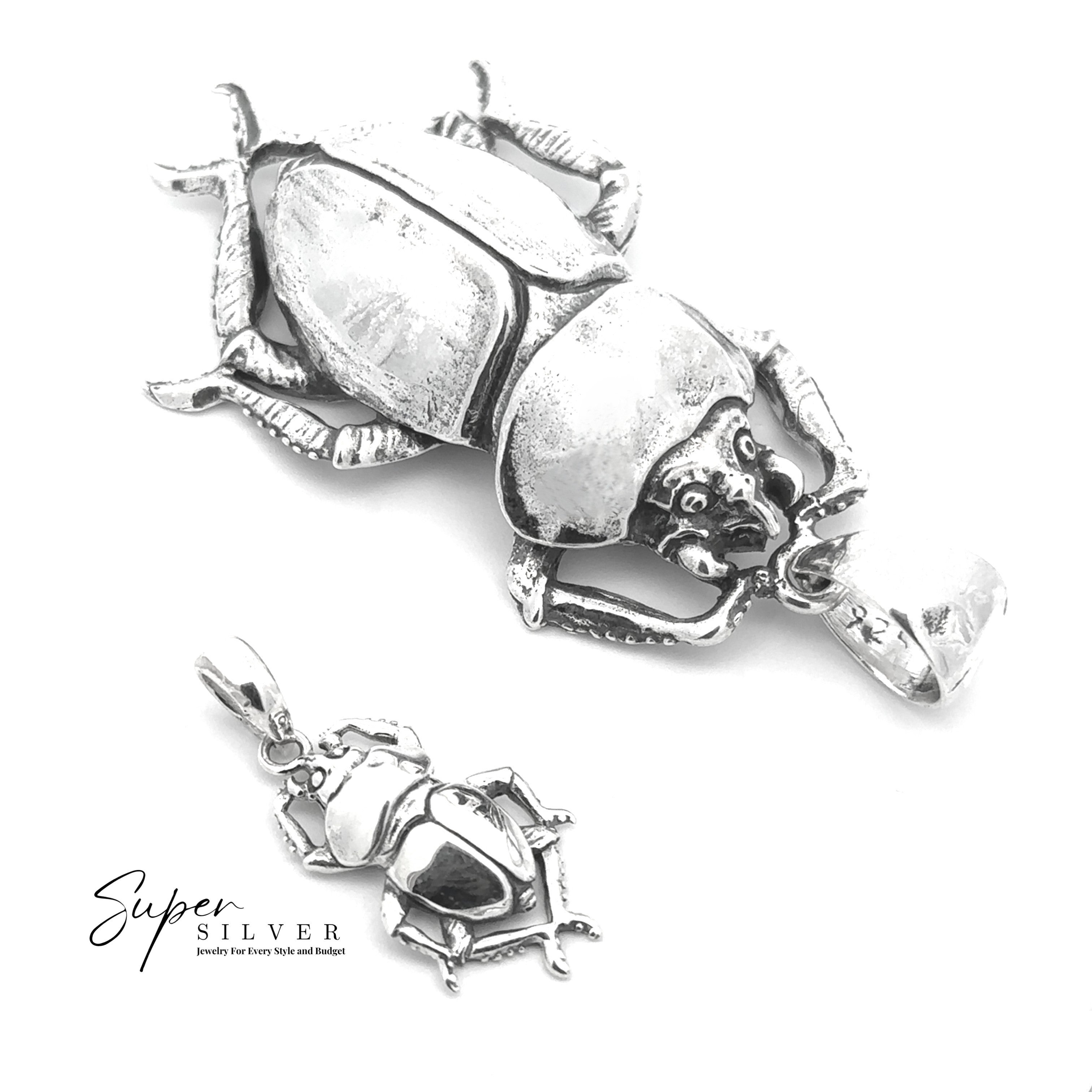 Two Beetle Pendants, inspired by Egyptian jewelry—one large, one small silver piece—are shown on a white background with the "Super Silver" logo in the bottom left corner.