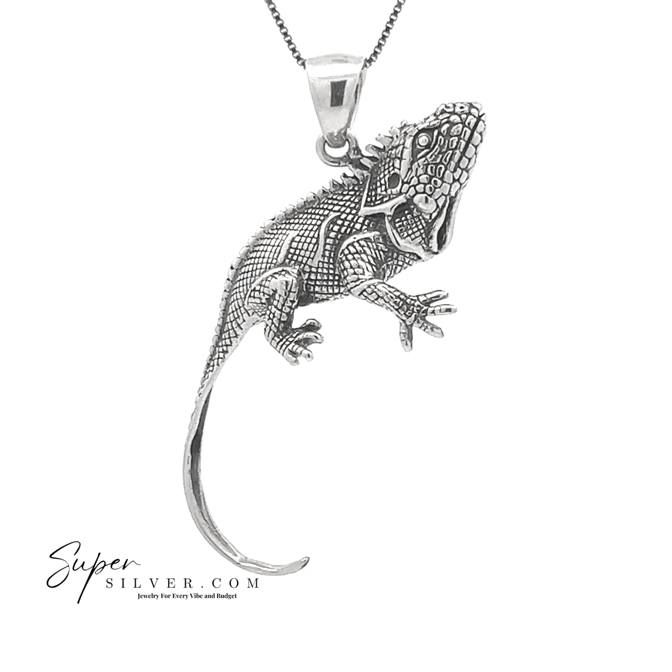 The Iguana Pendant from the Artssina Collection is displayed on a chain against a white background, with the "Super Silver" logo in the lower left corner—an elegant silver piece for any iguana jewelry collection.