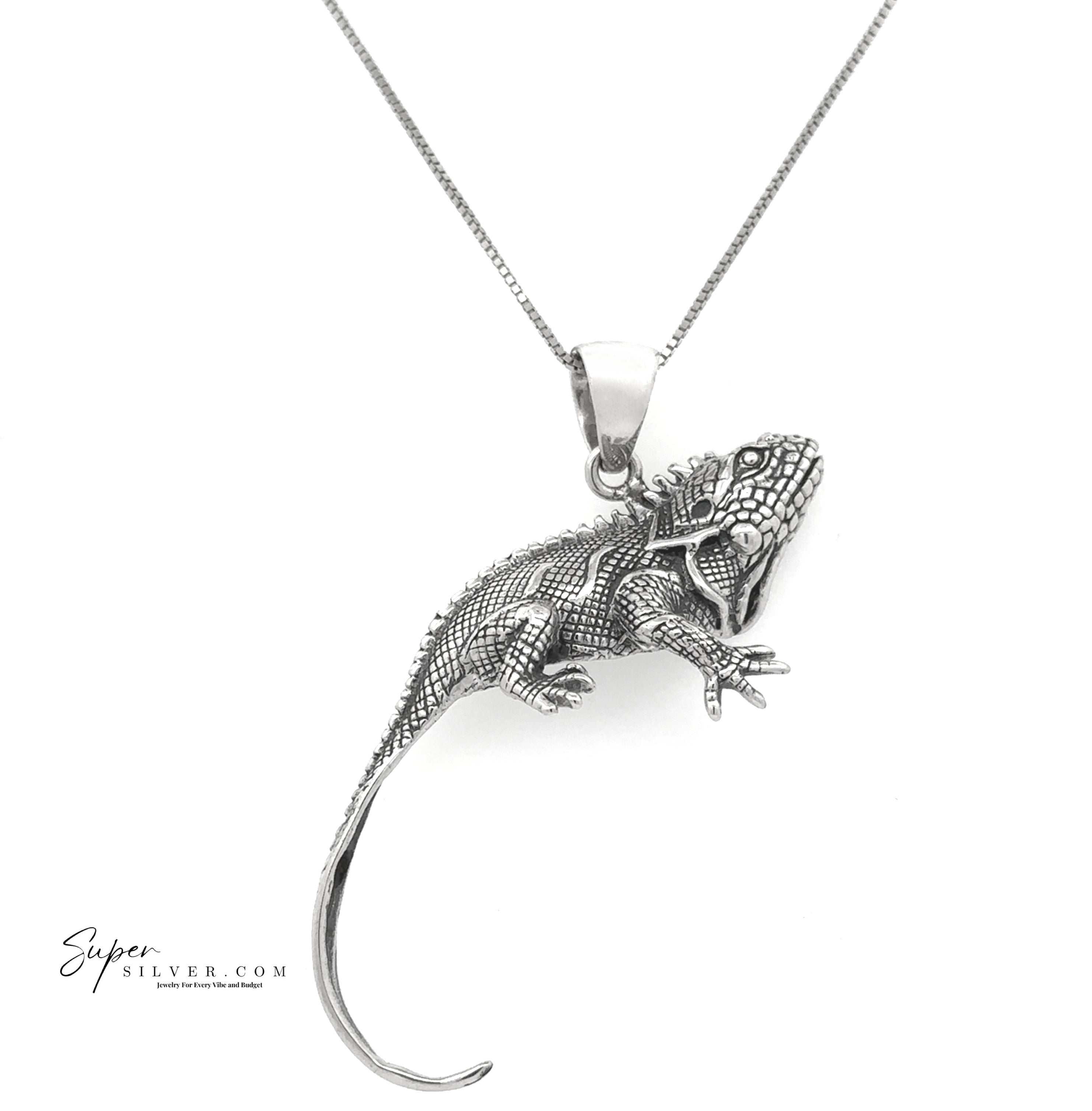 The Iguana Pendant from the Artssina Collection is crafted in sterling silver with textured scales and a curled tail, displayed on a white background. A striking choice for any iguana jewelry collection.