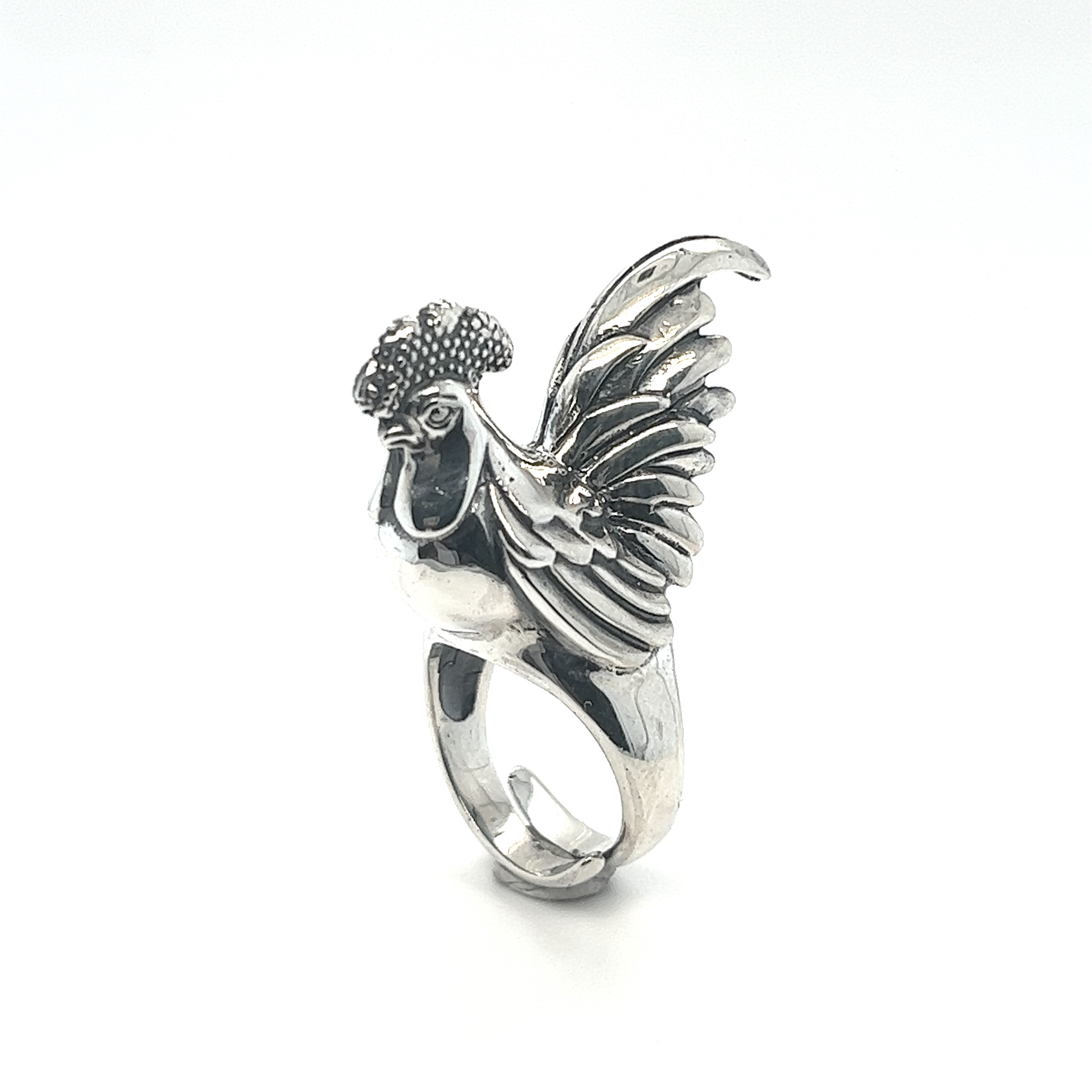 An Exceptional Rooster Ring with intricate silver work on a white background.