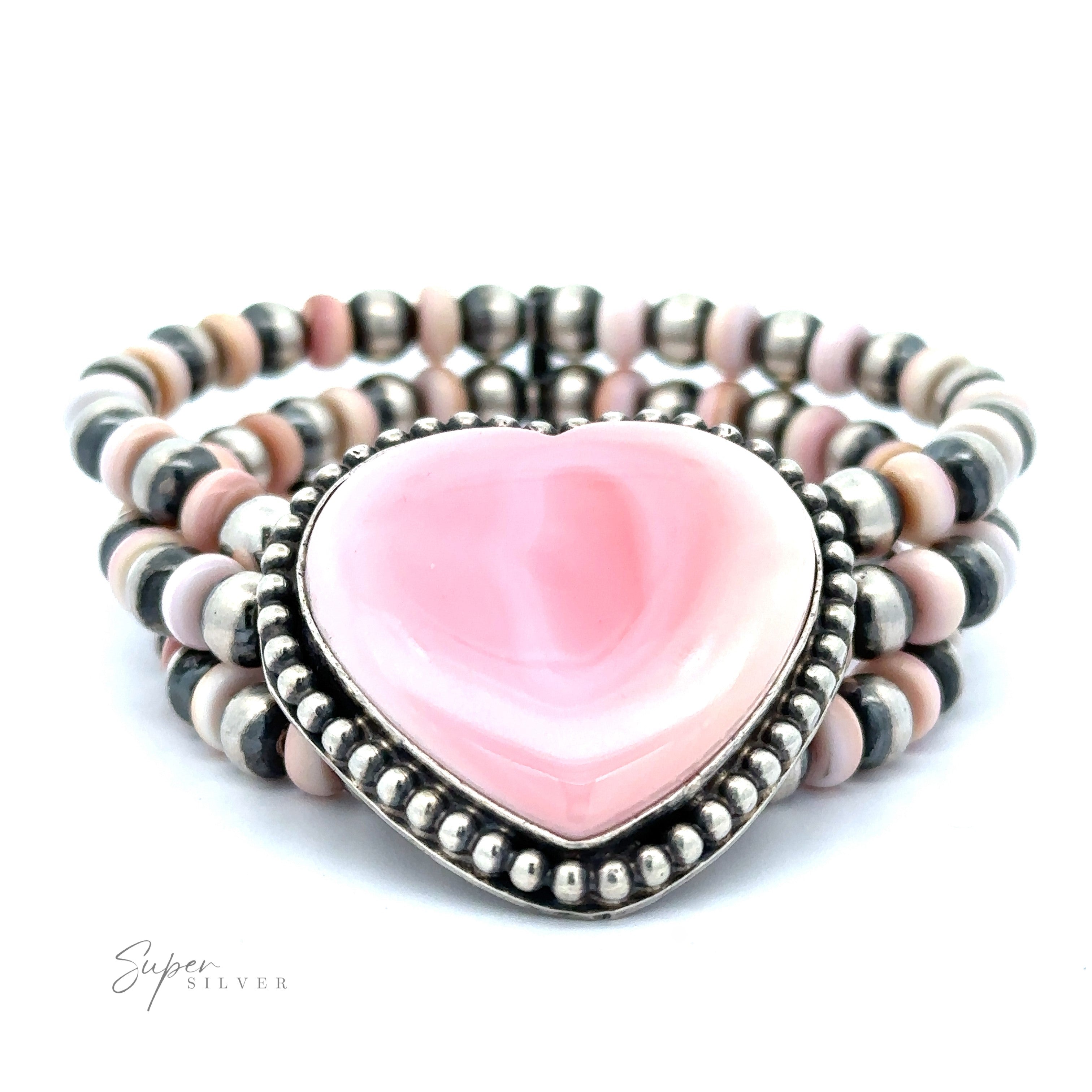 A Native American Beaded Conch Heart Bracelet featuring a large pink heart-shaped stone surrounded by a Navajo pearl beads frame, set against a white background.