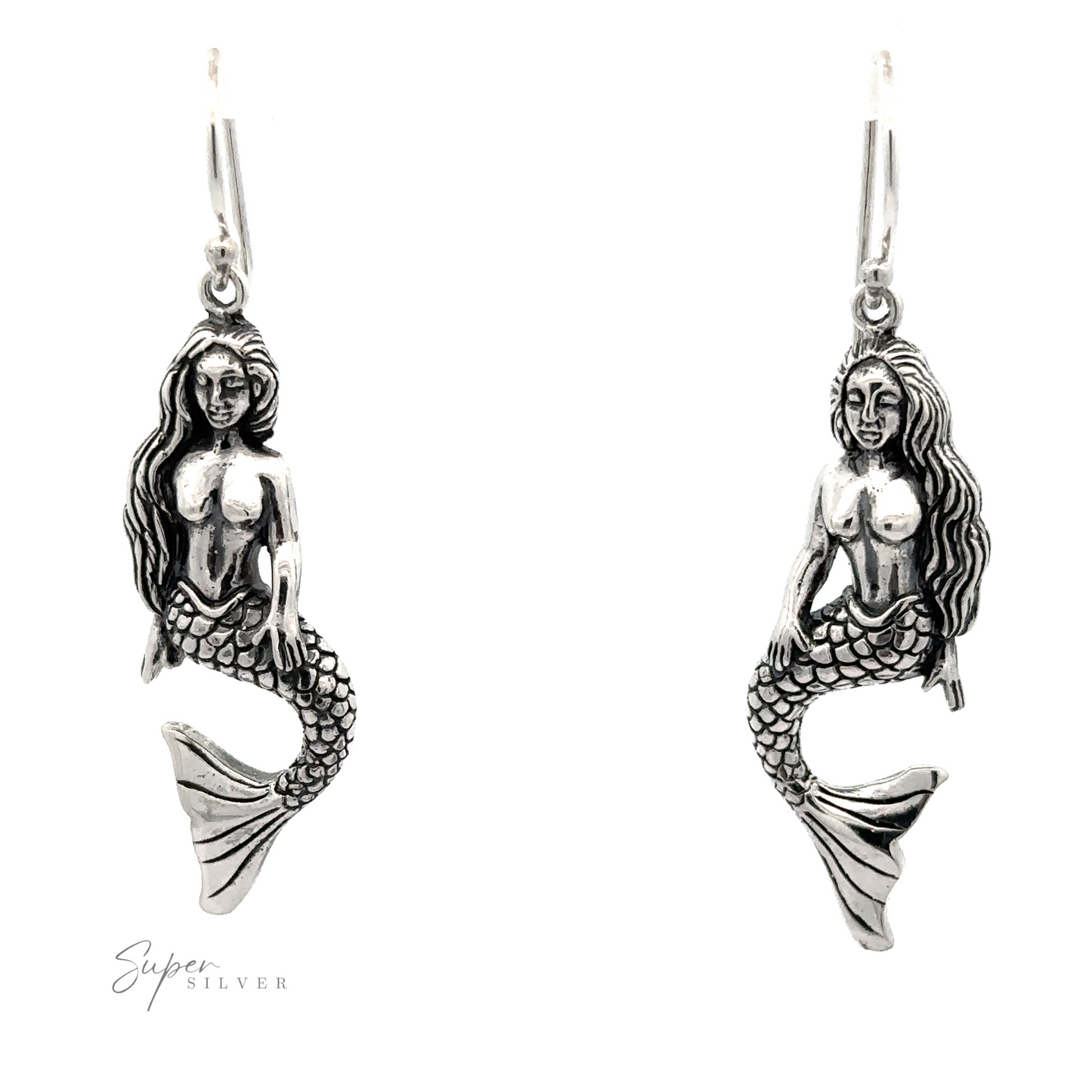 Pair of sitting mermaid earrings with detailed design, hanging from hooks, displayed against a white background.