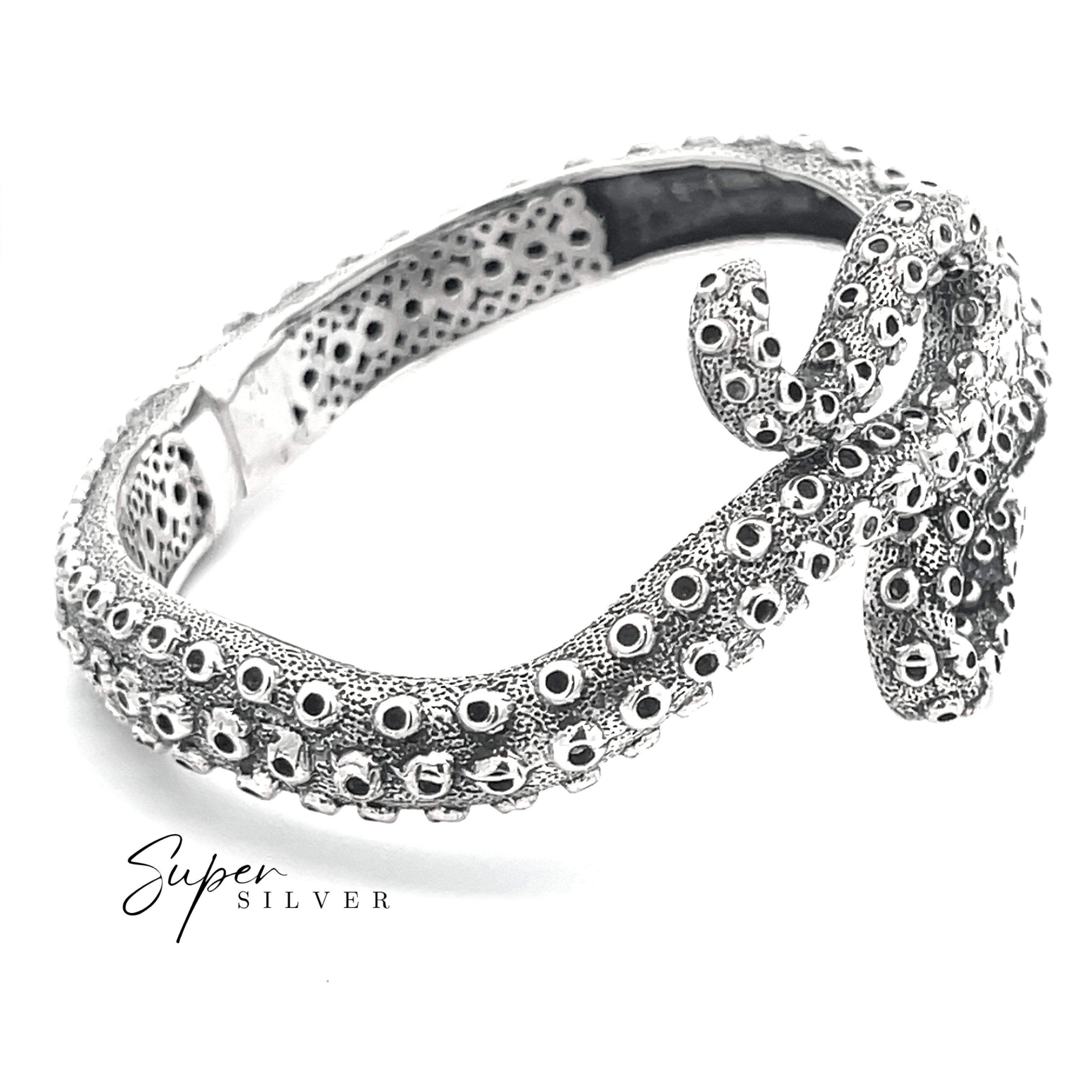 The Tentacle Hinge Cuff is a sterling silver bracelet featuring detailed octopus tentacles and suction cups, displayed on a white background. "Super Silver" in the corner highlights this distinctive artisan jewelry piece.