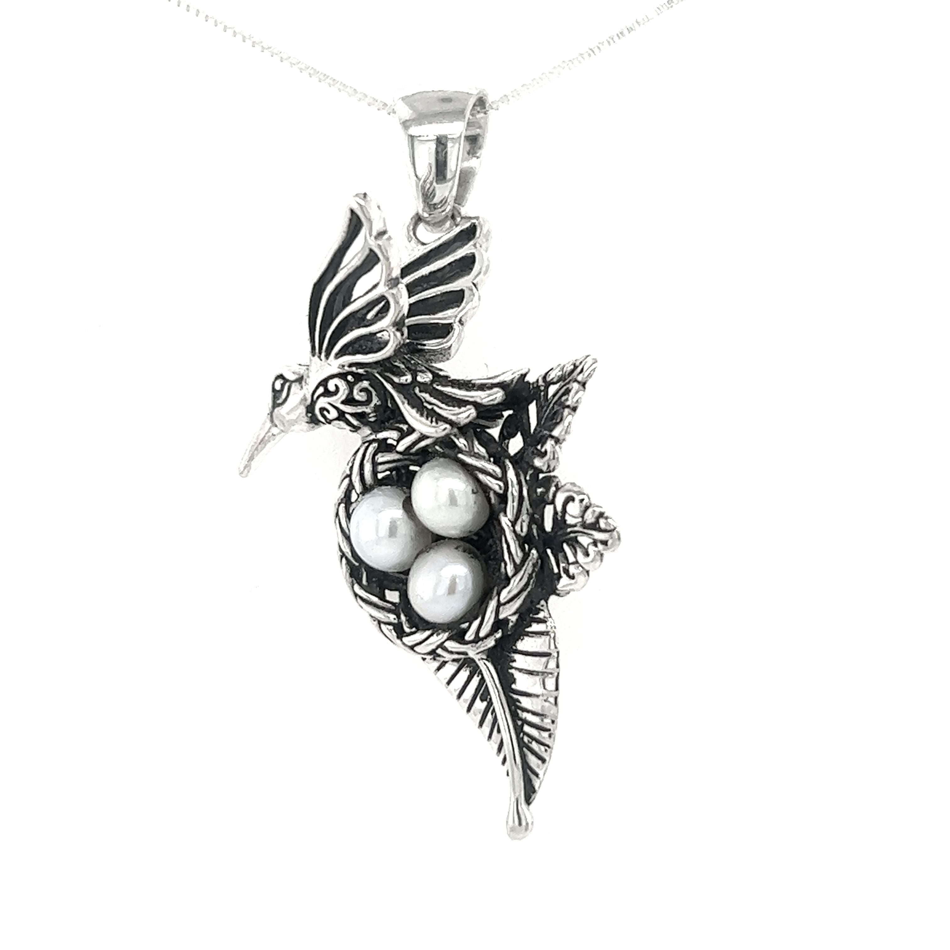 A Hummingbird Pendant with Nest of Pearls by Super Silver on a silver chain.